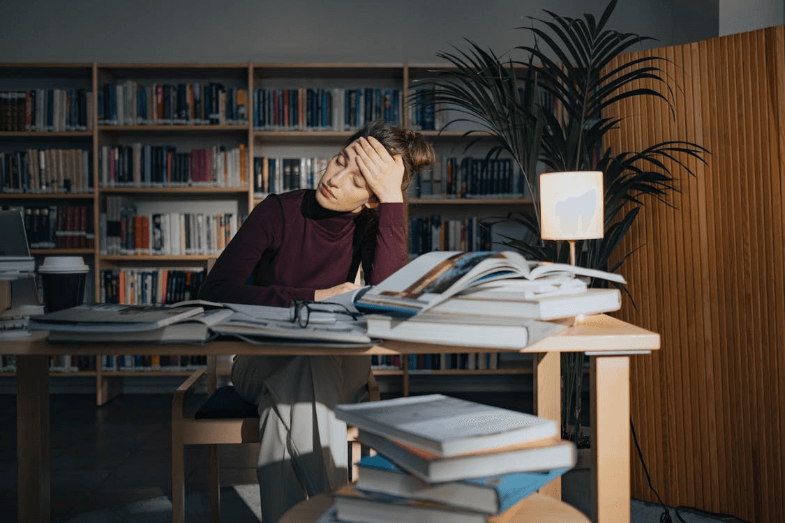 Woman Wearing a Long Sleeve Shirt, looking worried in front of a messy desk