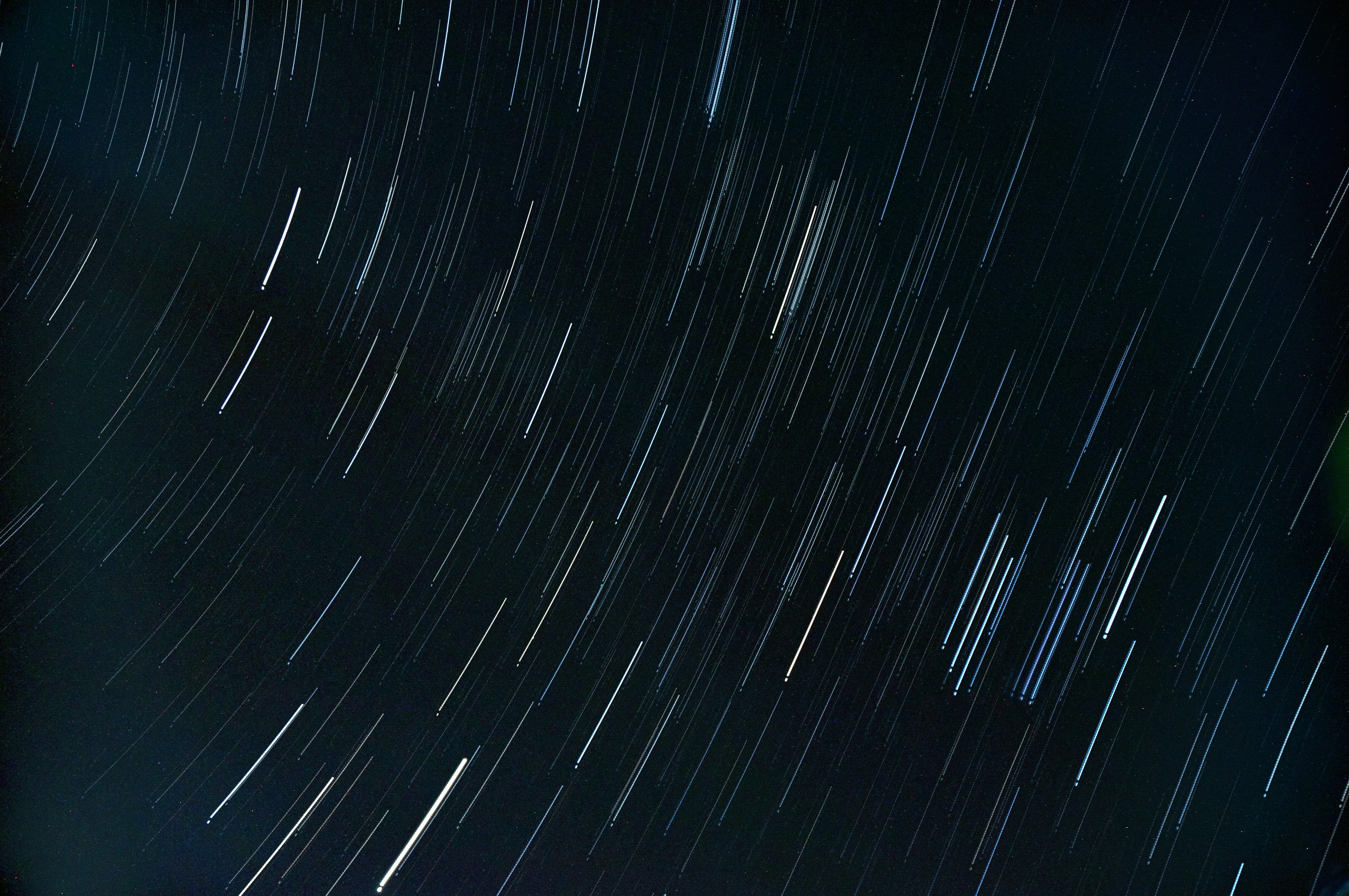 Star trails in the night sky over dark landscape