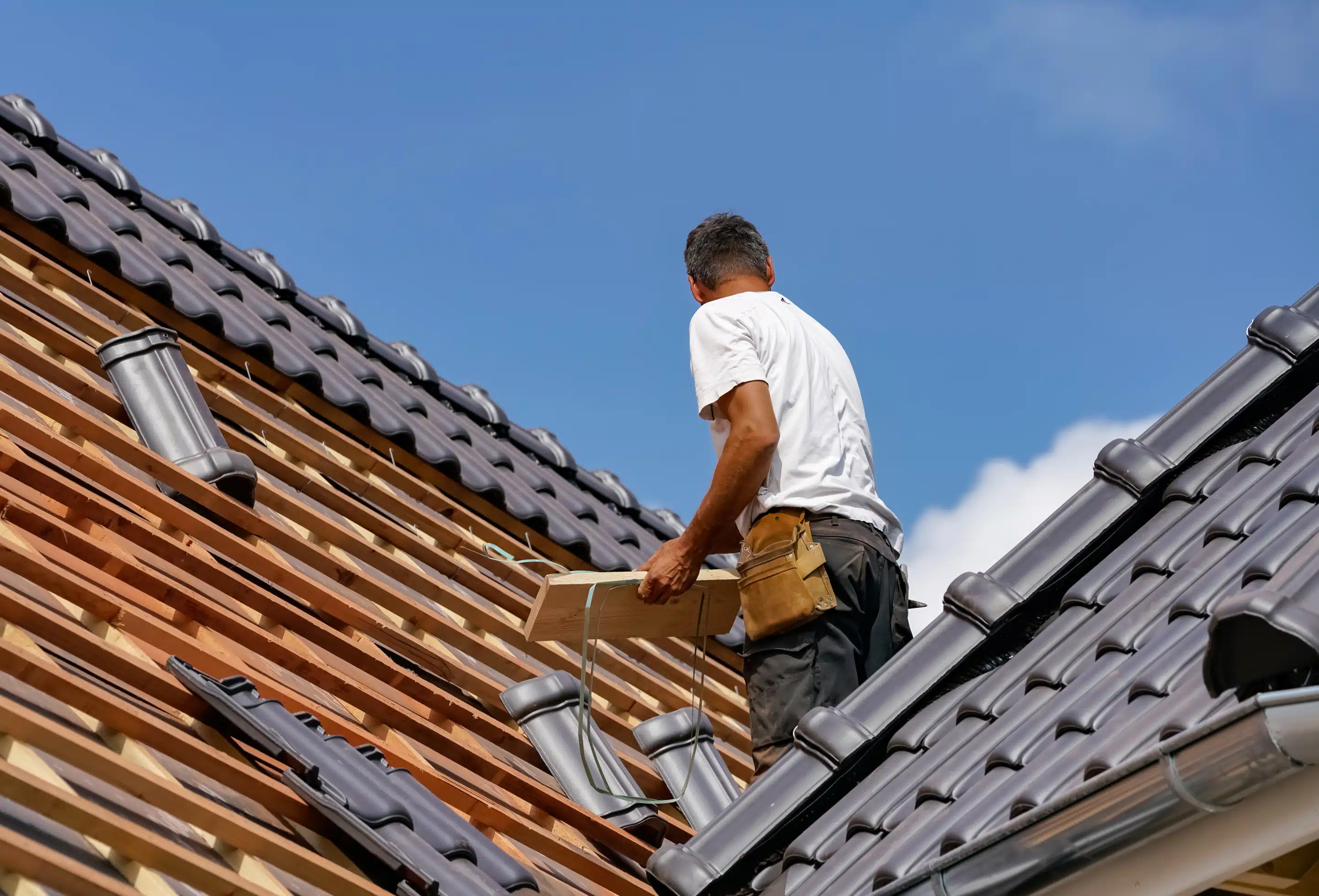 two men working on the roof of a house