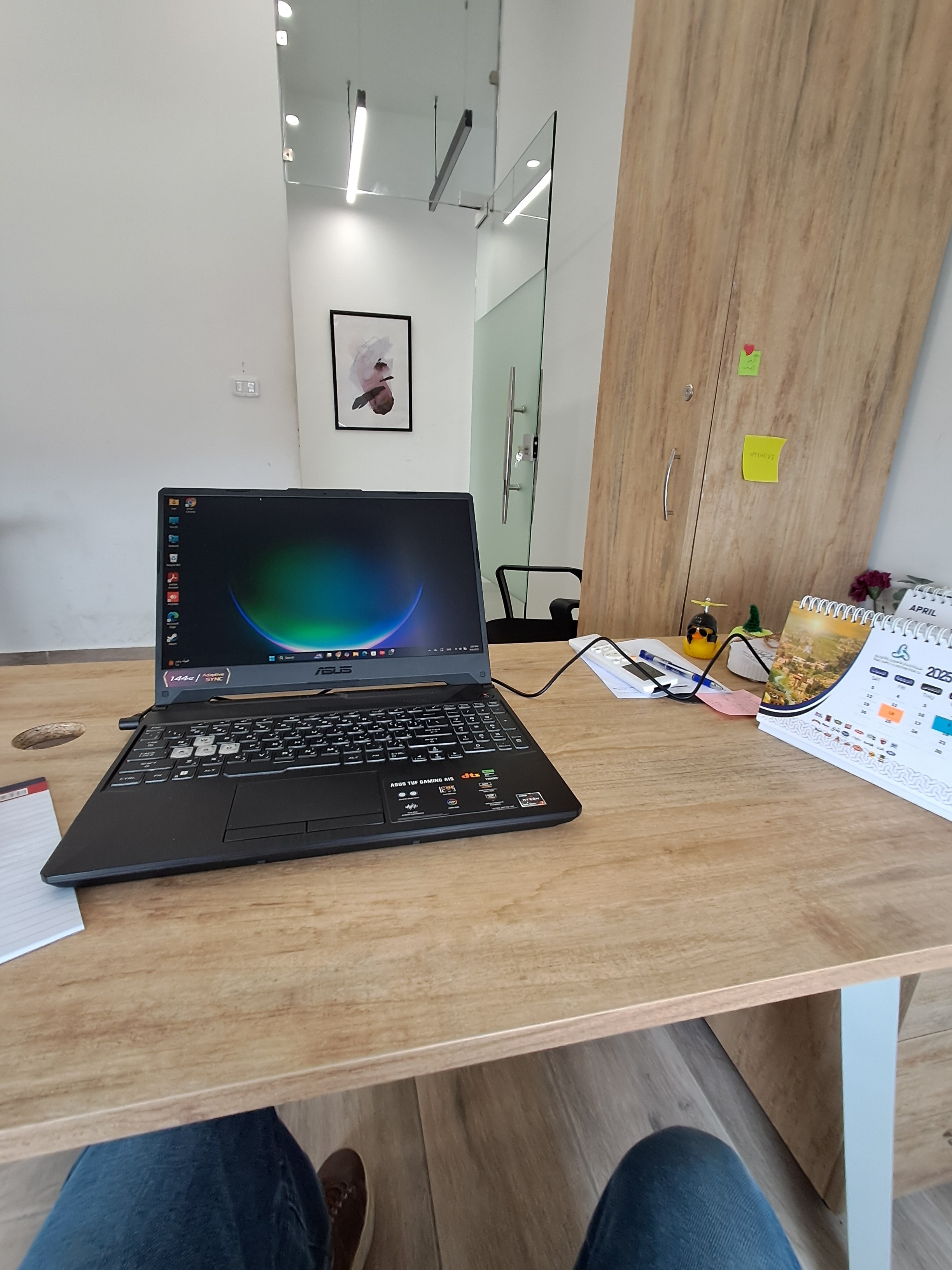 Man sitting in a dimly lit room, wearing a beige shirt and looking contemplative.