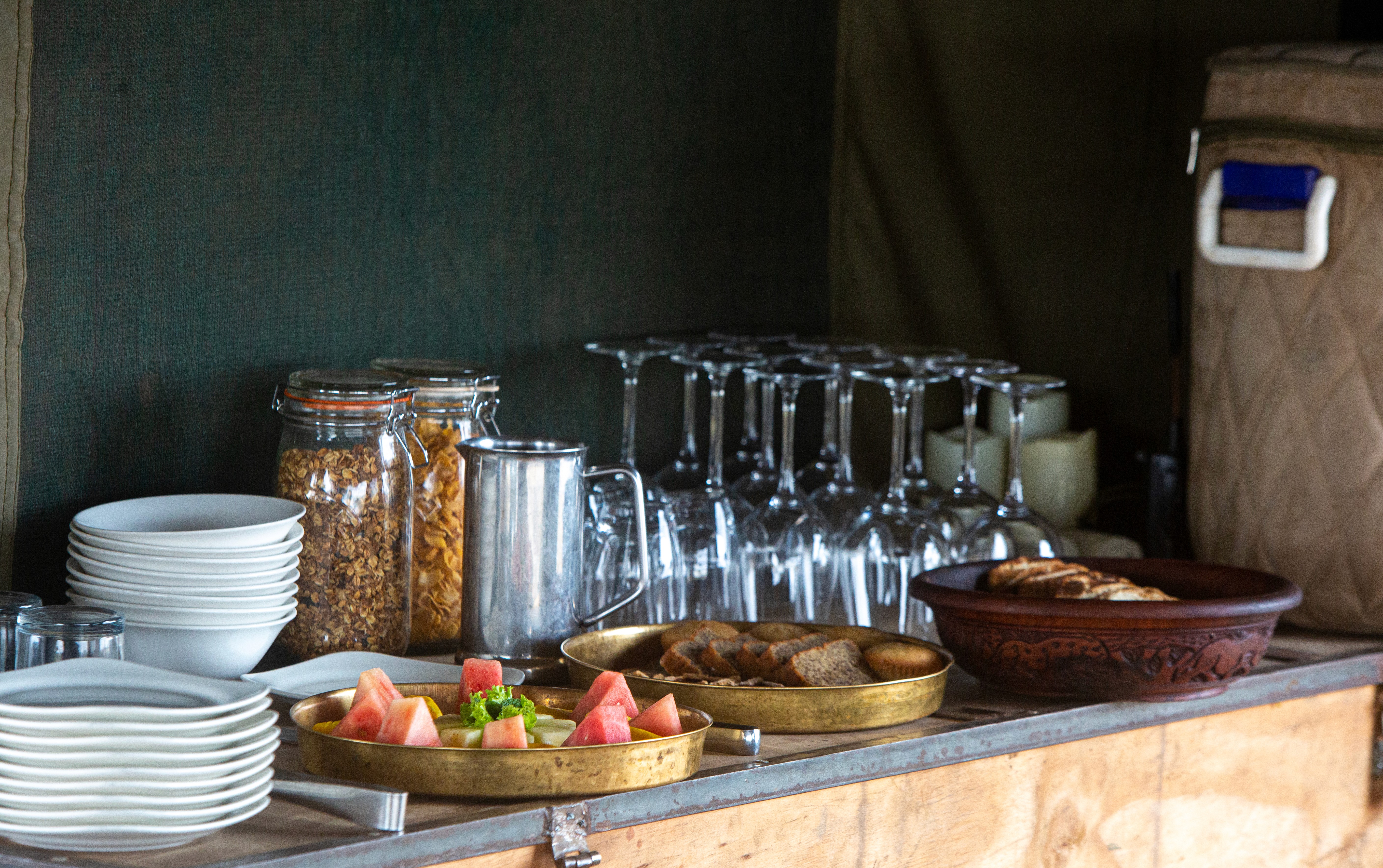Kilimanjaro Elephant Ride, Arusha, Tanzania. En kvinna sitter och läser utanför ett tält uppsatt i vildmarken.