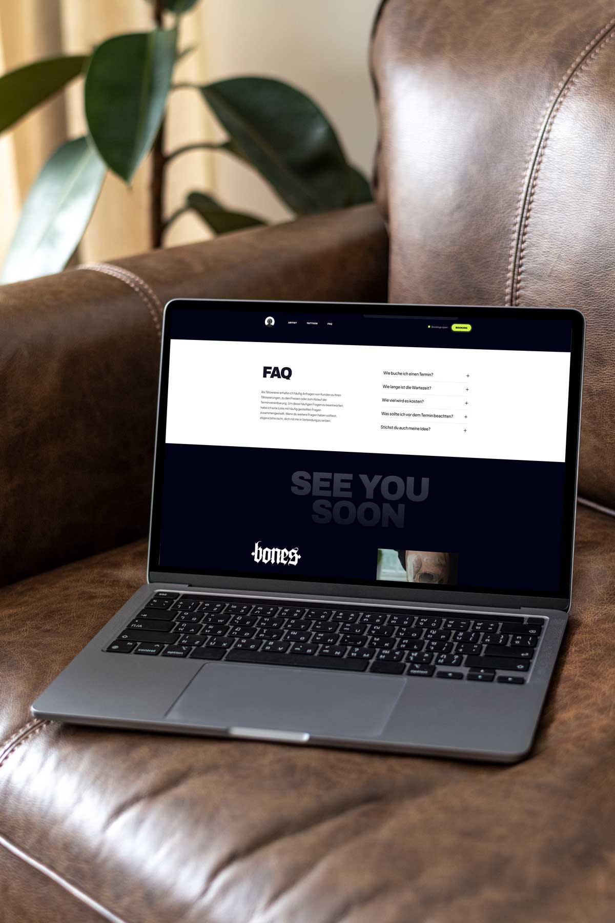 Mac book mit webdesign im Display stehend auf einer braunen ledercouch