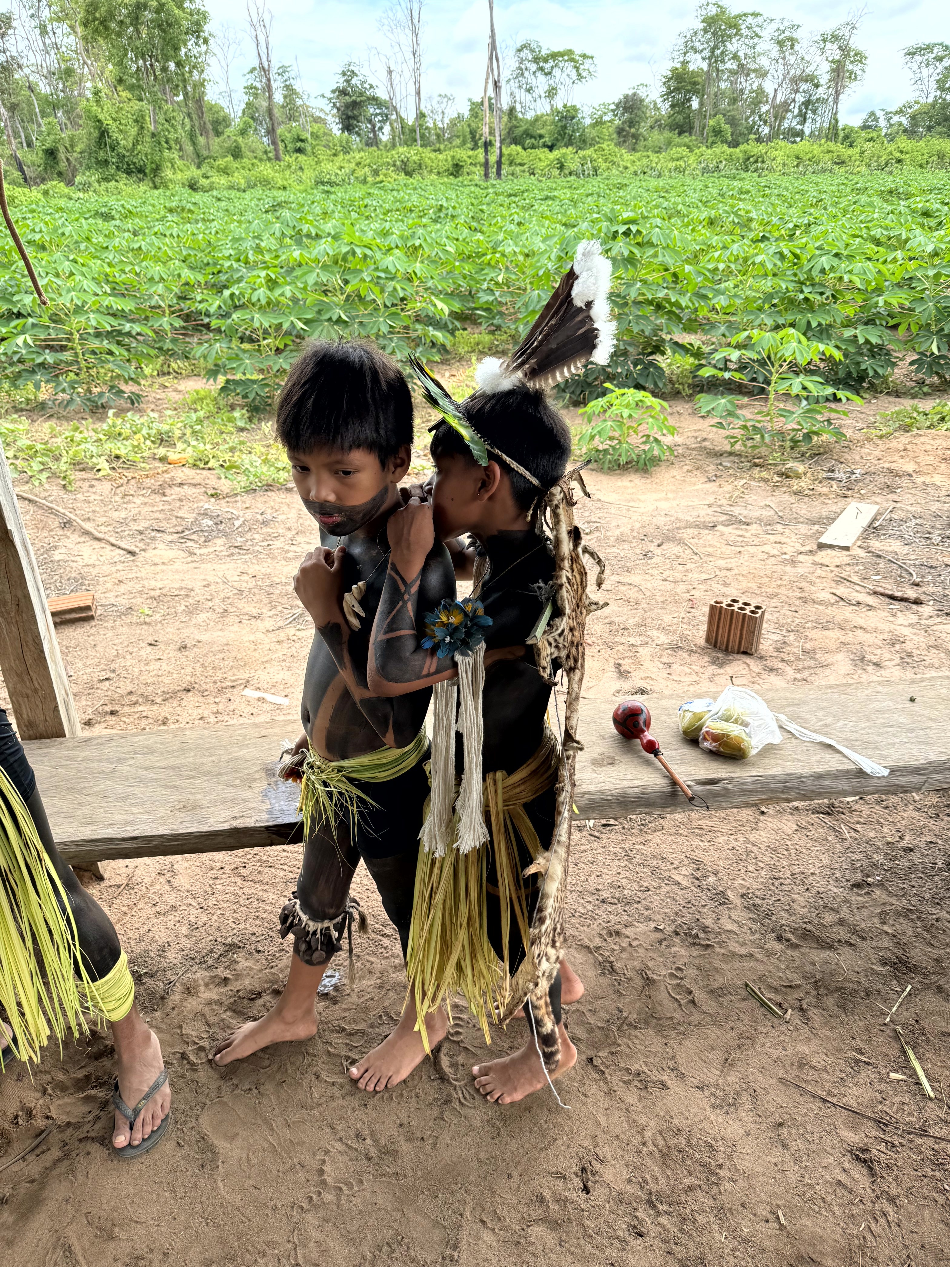 Zwei Kinder des indigenen Volkes der Balatiponé Umutina in traditioneller Bemalung und Kleidung bei einer liebevollen Umarmung im Reservat bei Barra do Bugres – ein stiller Moment voller Nähe und Vertrauen.