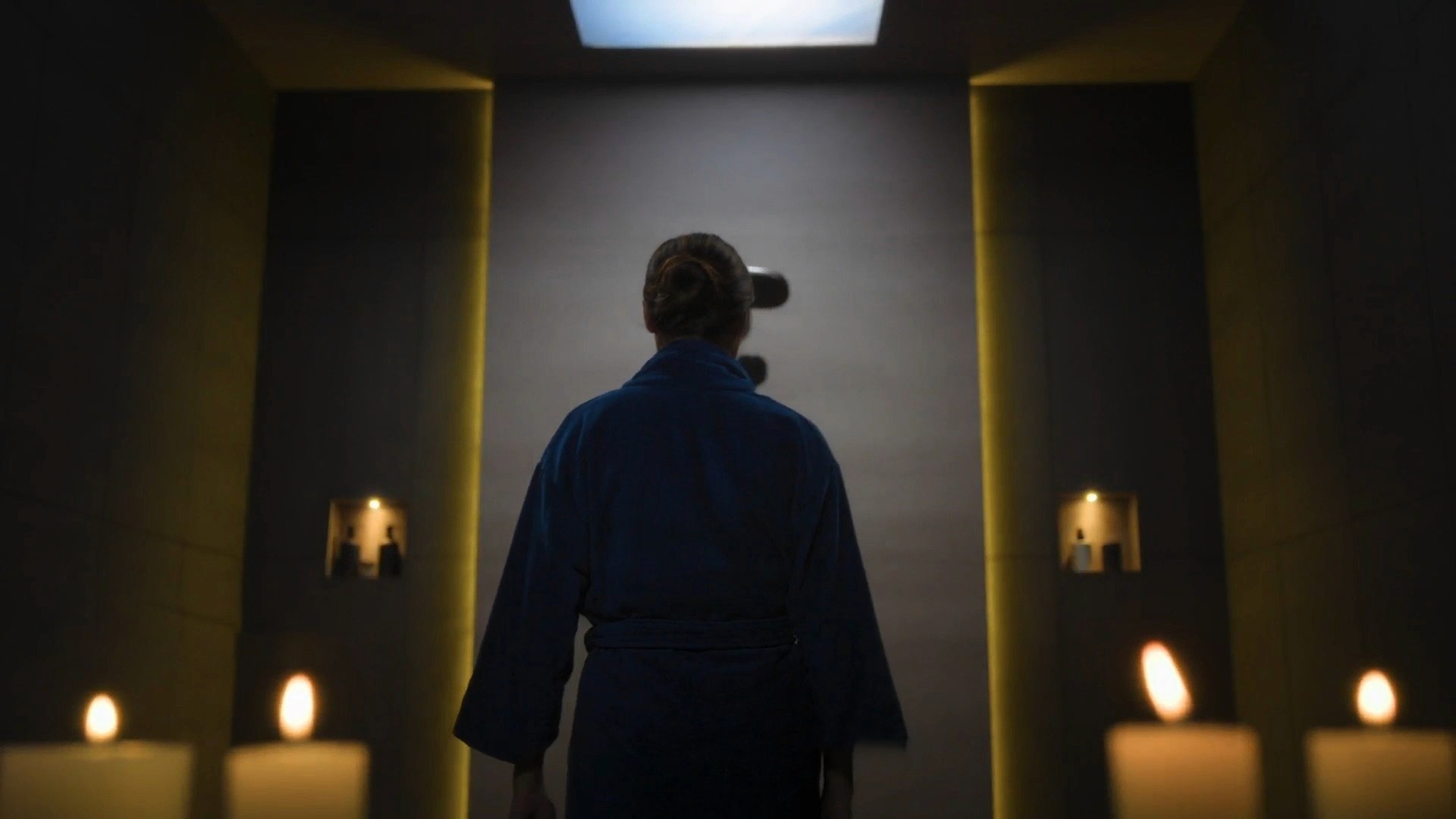 Person walking into a modern bathroom in a TOTO India product video scene.