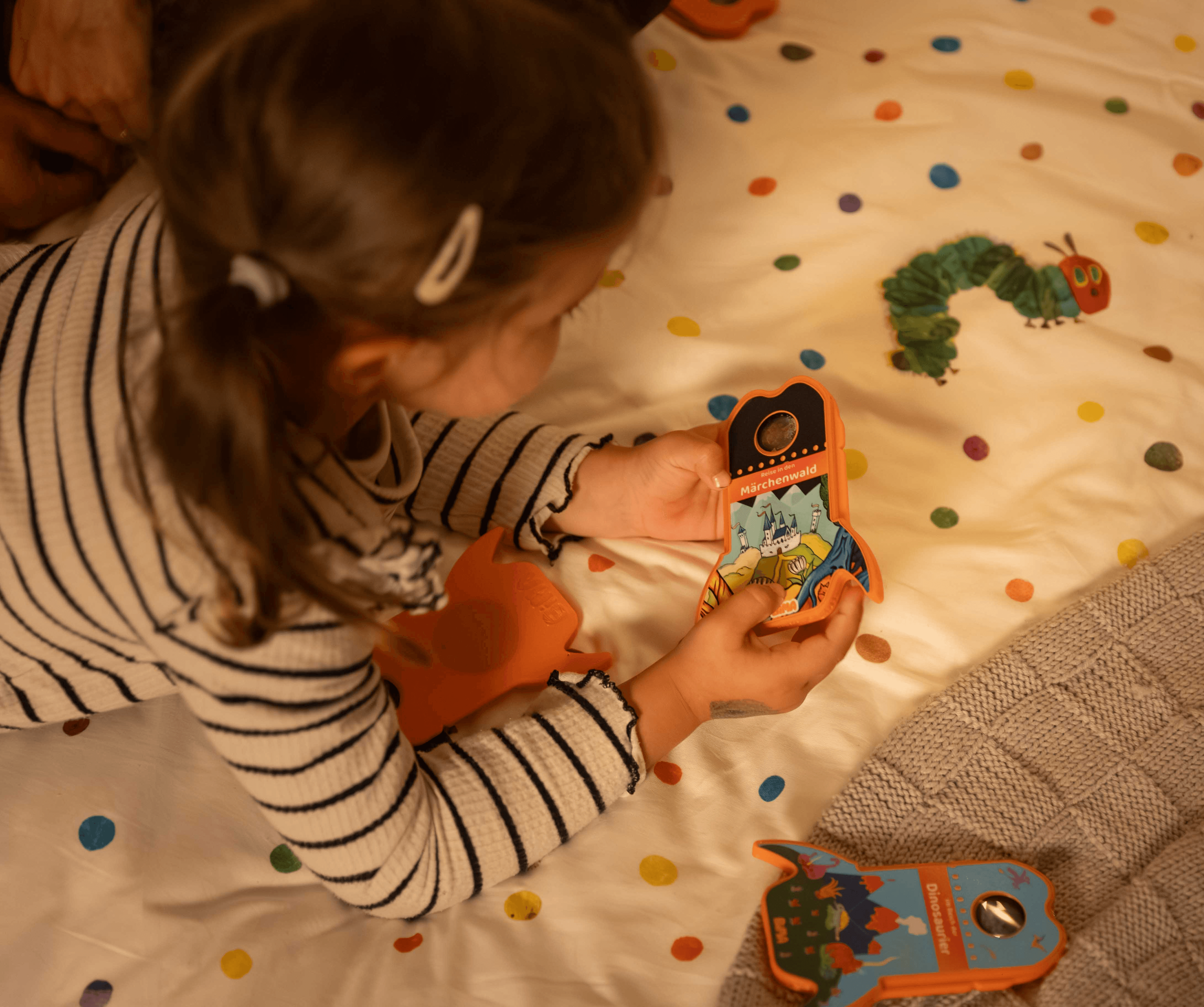 Ein Kind liegt auf dem Bett und schaut sich die BiMA Raketen an