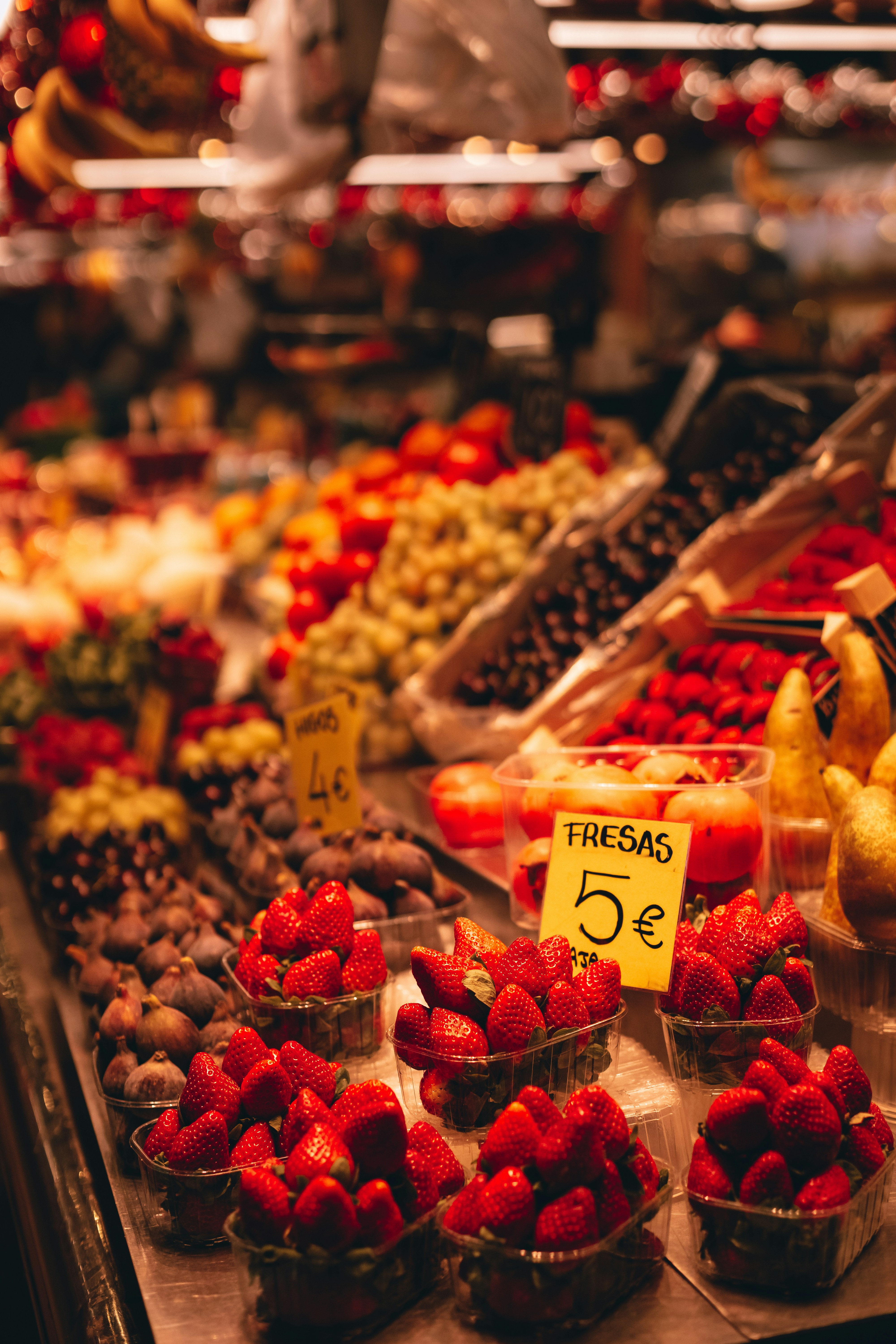 A fruit stand with strawberries, bananas, and other fruits