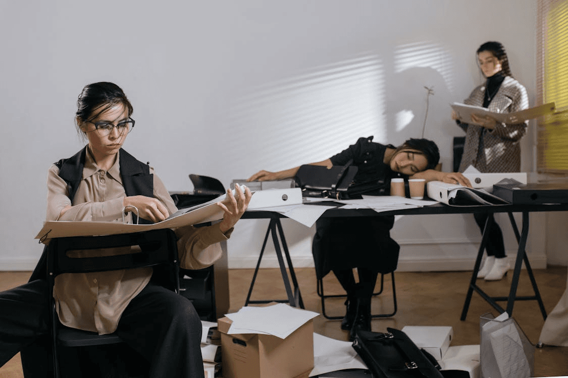 Women in the Office, looking tired while doing busy work