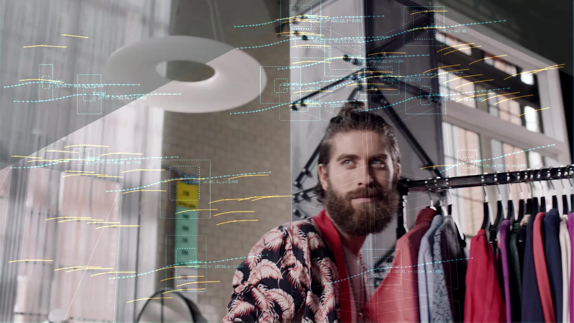 Image of a man standing in front of a clothing rack, overlaid by camera tracking marks.