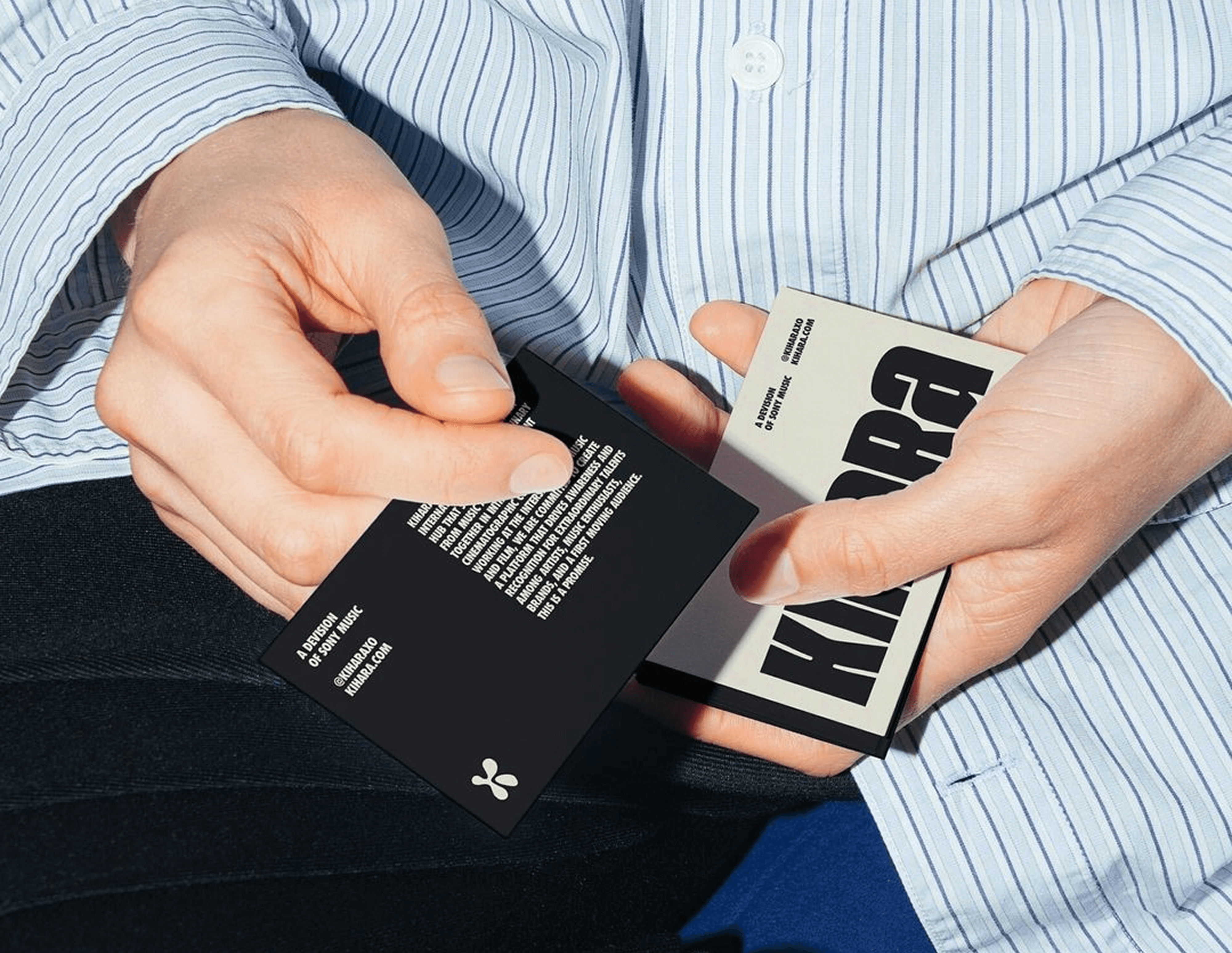 Hands holding black and white business cards