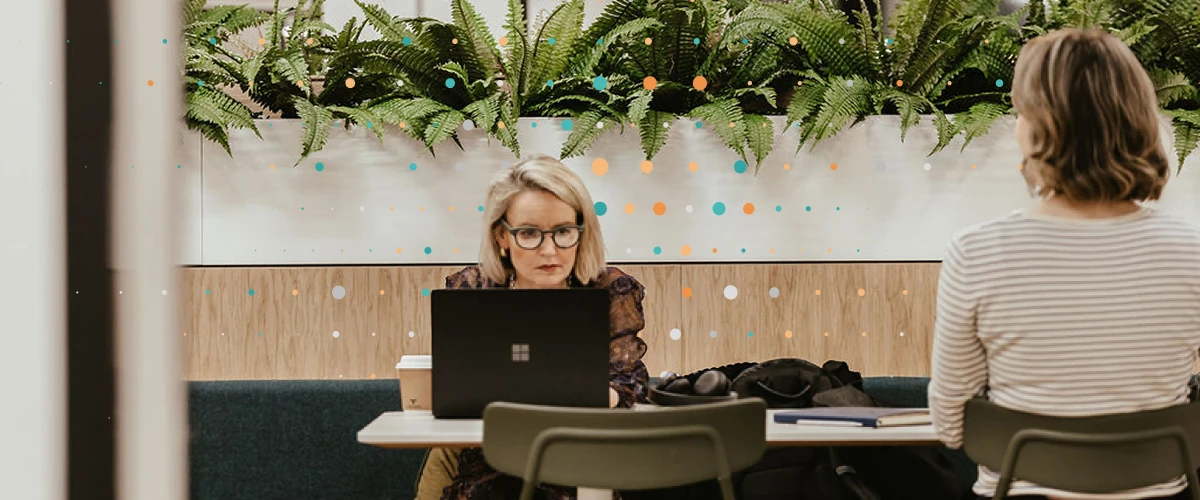 two lean tree team members sat in a coworking space working at laptops