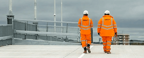Modern glass building with illuminated trees and a view of city skyscrapers