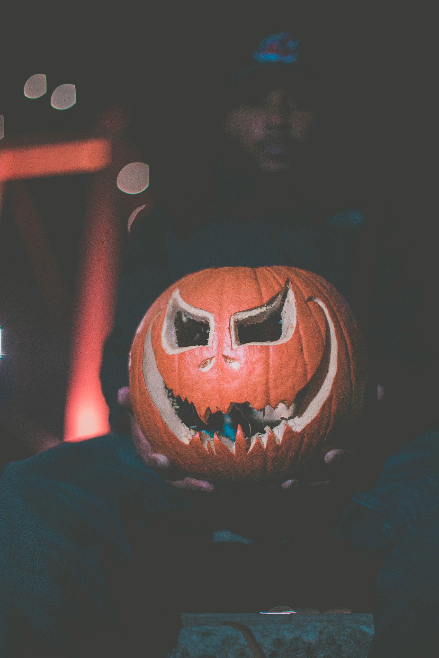 Carved pumkin with man in the background