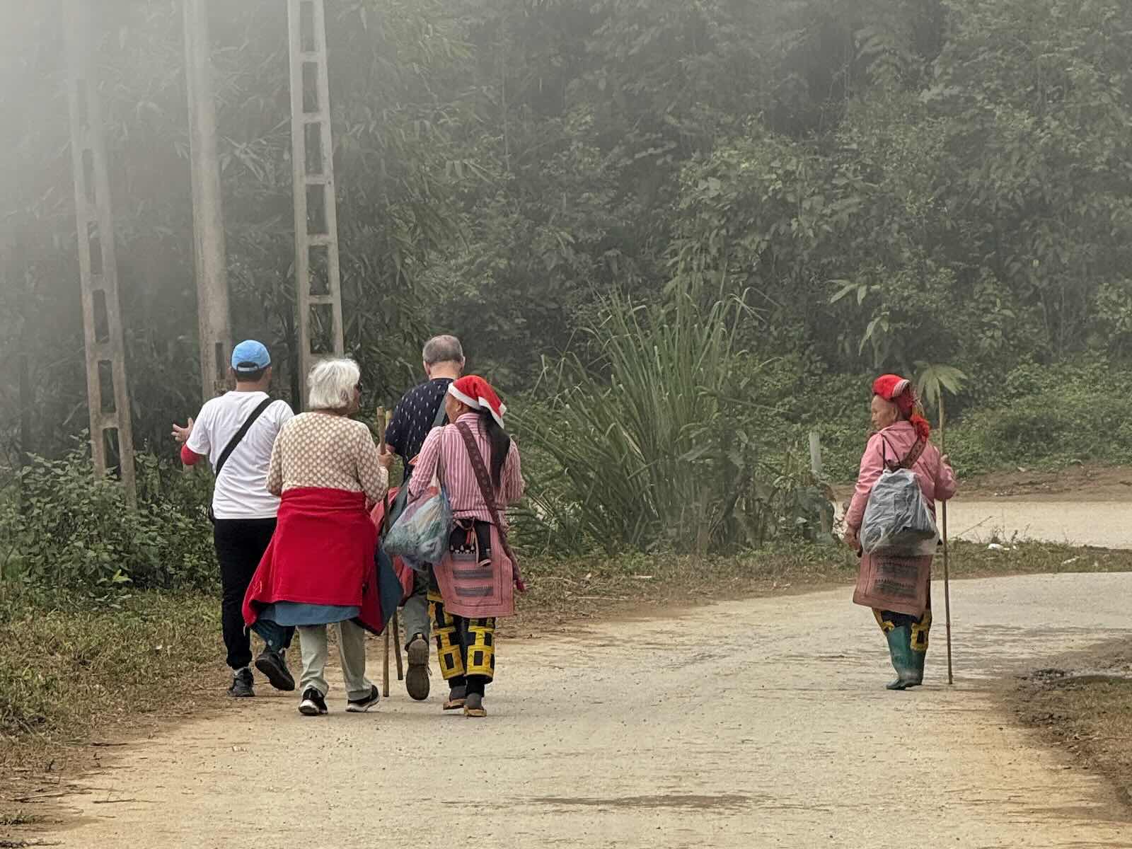 Red Dao women walking with visitors near Ta Phin village