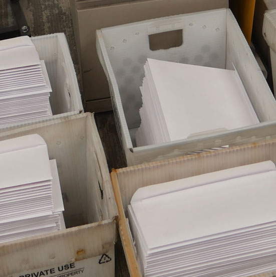 overhead image of freshly inserted envelopes sitting in containers