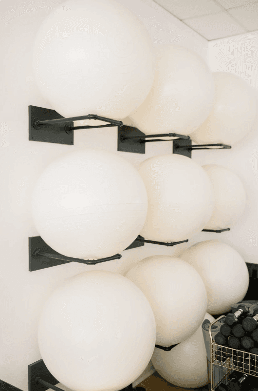 Hand in lace sleeve holding a lit white candle against a red background, wearing a silver ring with a dark gemstone.