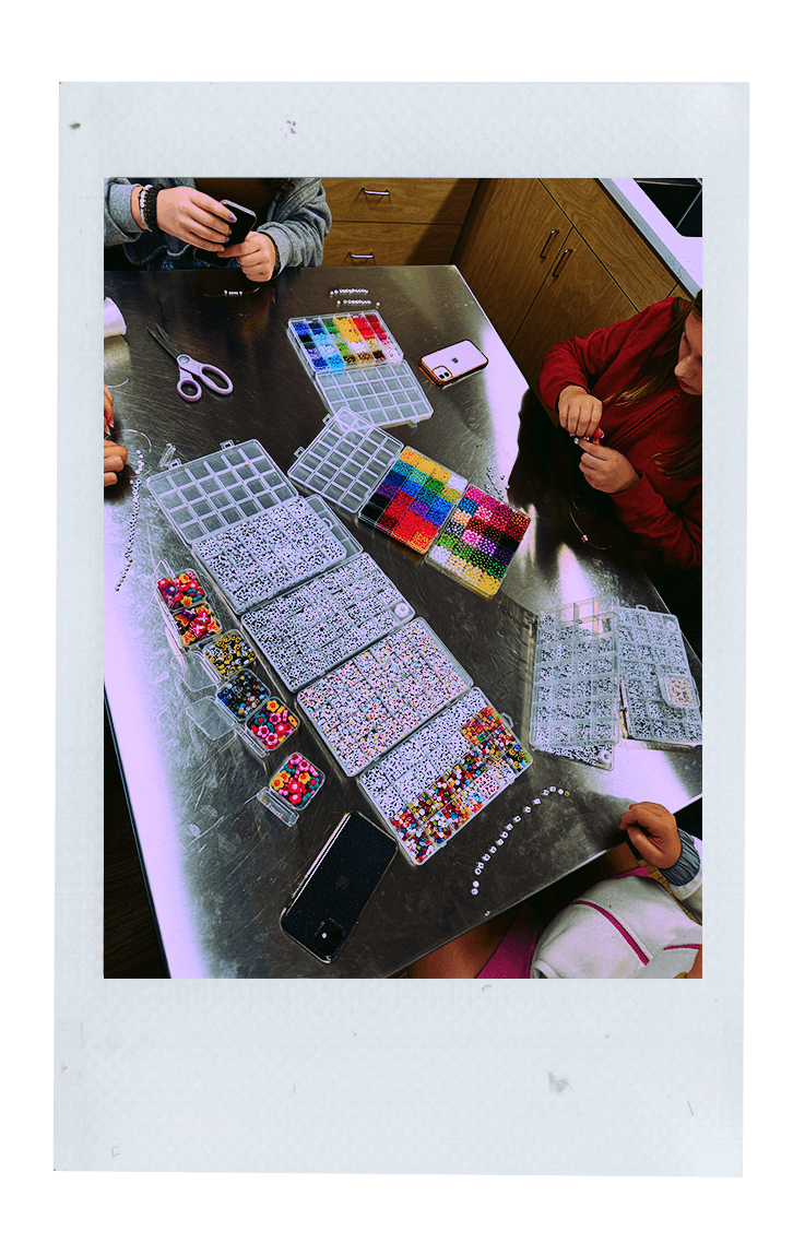 Fujifilm photo of tween girls making a friendship bracelet