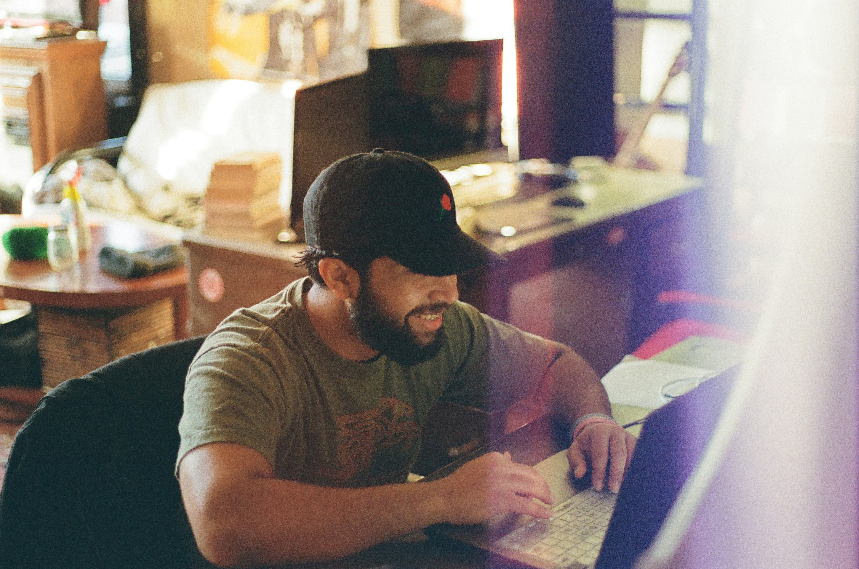 Small business owner reviewing financial spreadsheets on a laptop at a wooden table, working through the numbers.