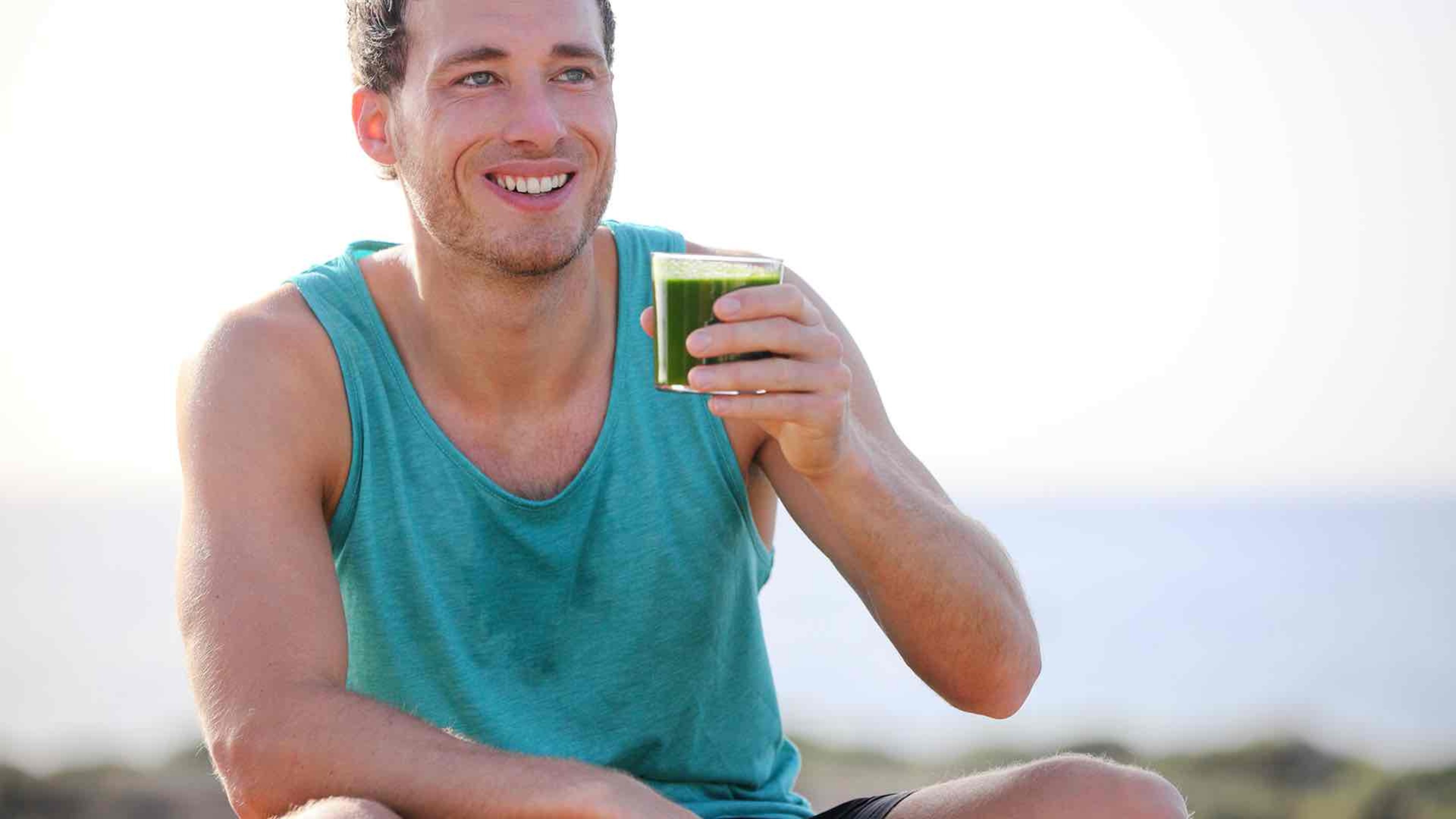 man with a glass of green drink