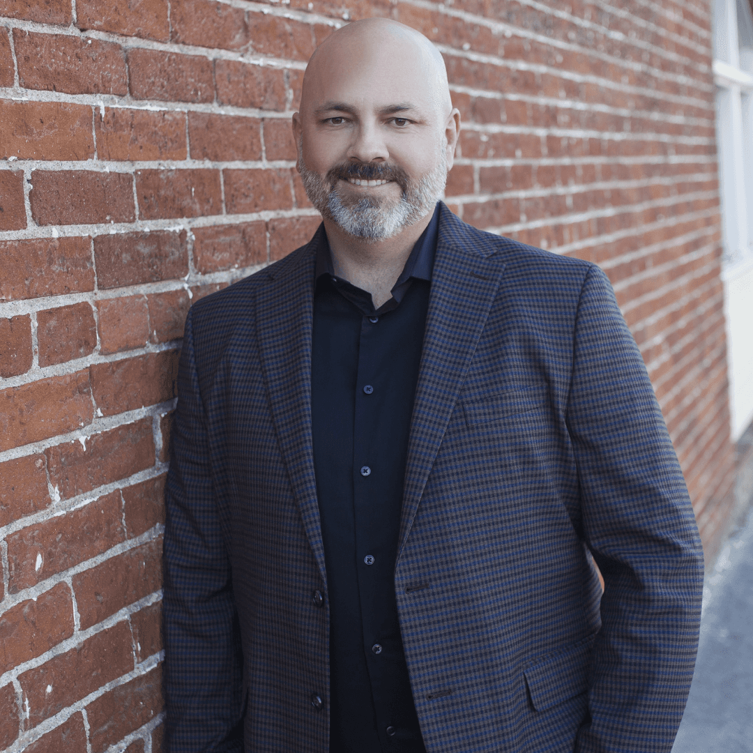 Josh Long, Sales Team Expert, standing in front of a brick wall, ready to help businesses fix their underperforming sales teams.