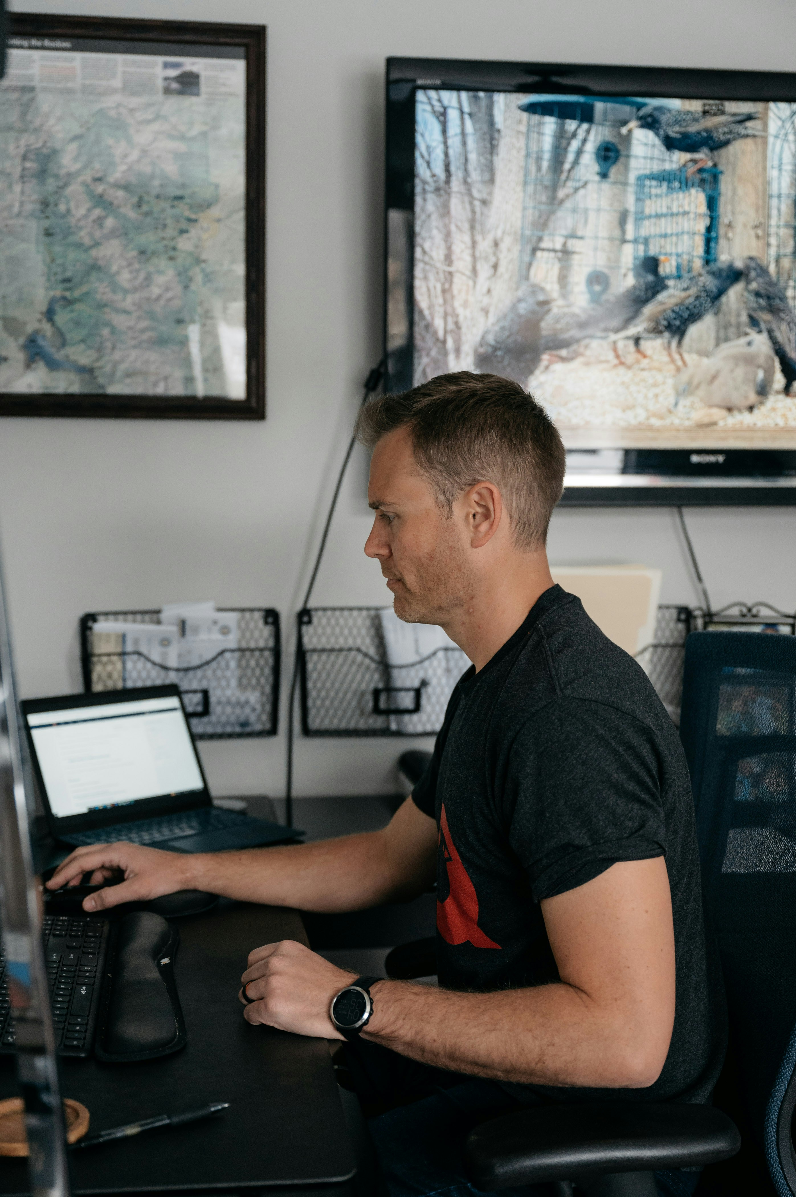 a man sitting at a desk with a laptop