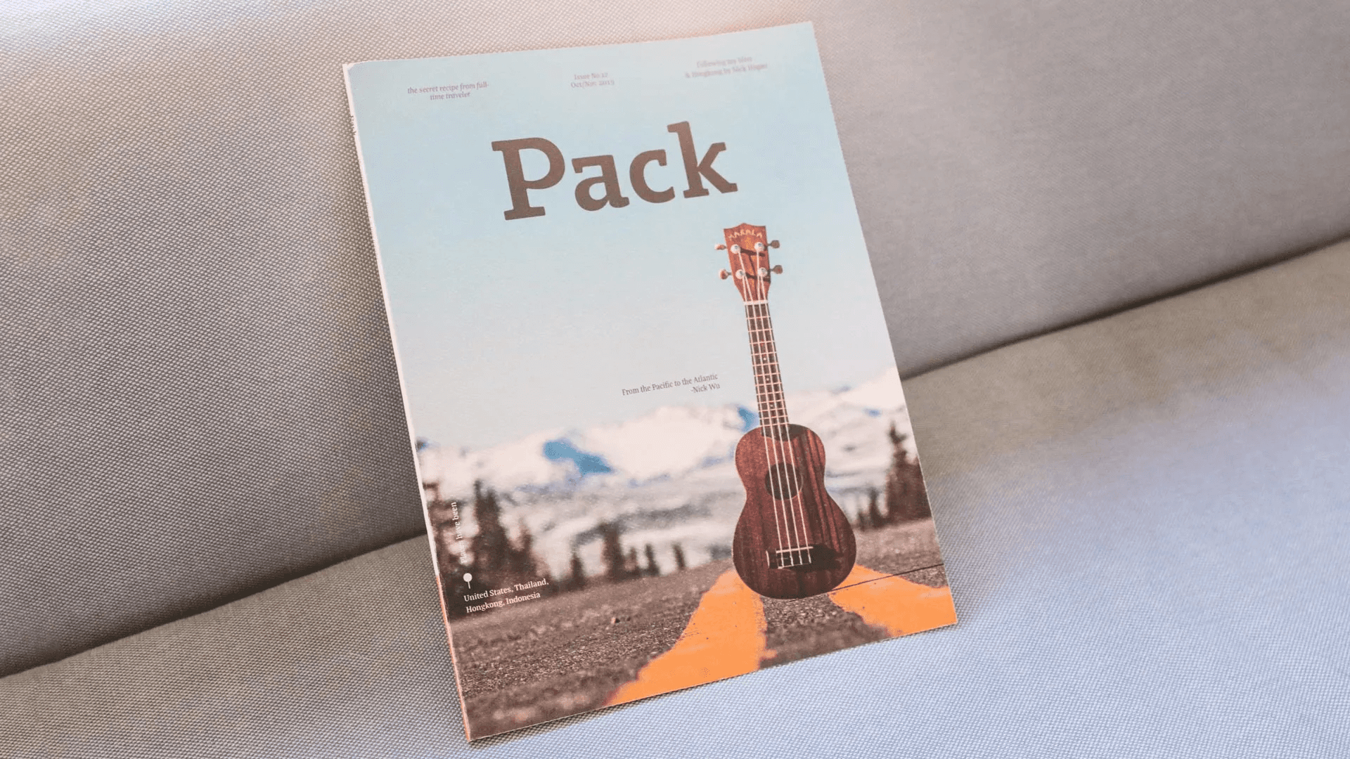 A sample page from the magazine "Pack," showcasing creative typography and vibrant visuals that capture the essence of full-time travelers' exciting experiences.