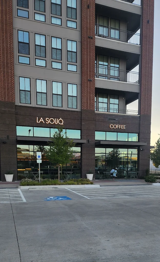 La Souq Coffee storefront with illuminated exterior signage on brick building façade.