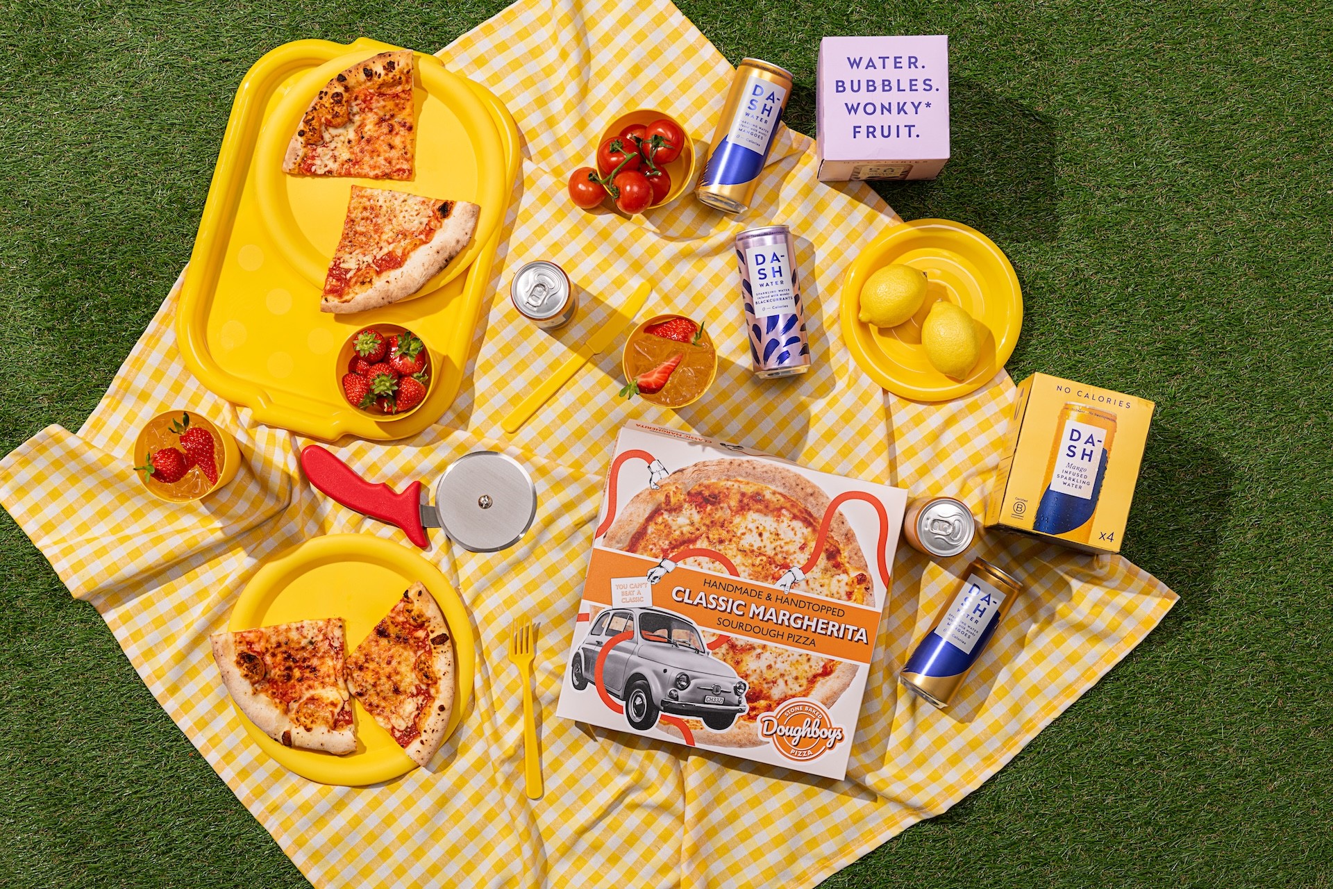 a picnic with pizza, strawberries, and water