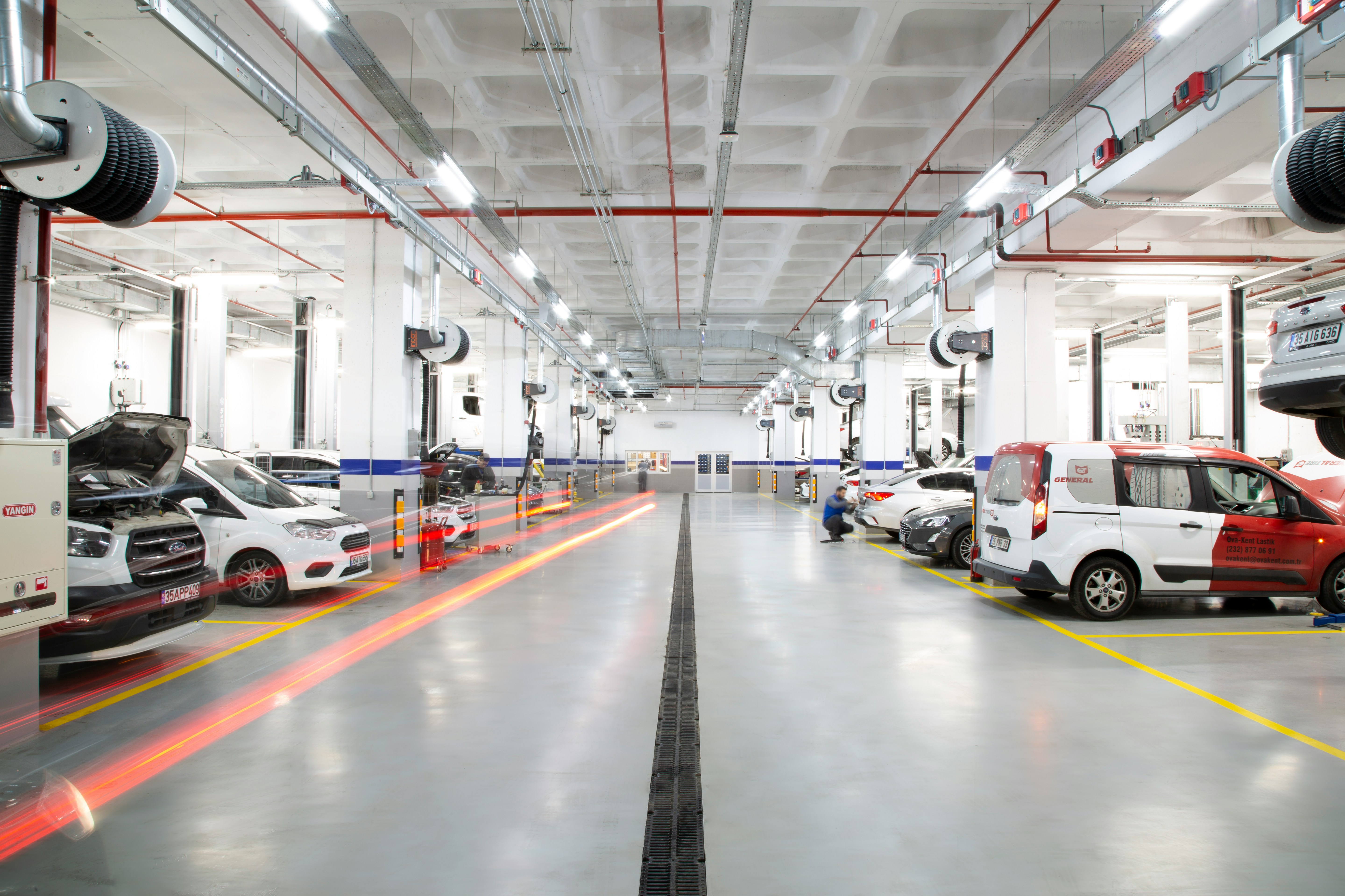 A large warehouse with many cars parked in it