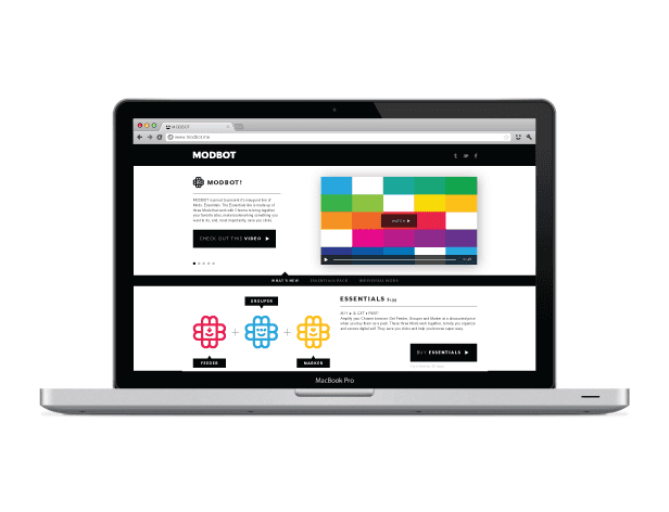 A silver MacBook Pro laptop is open, displaying a webpage titled "MODBOT." The page features a color palette generator interface with colored squares and a text description. A navigation bar includes "READ MORE," "MODBOT," "FEEDER," "MARKETS," and "MARKETS PRO." A sidebar displays "ESSENTIALS" with pricing information. The laptop’s web browser is visible at the top.