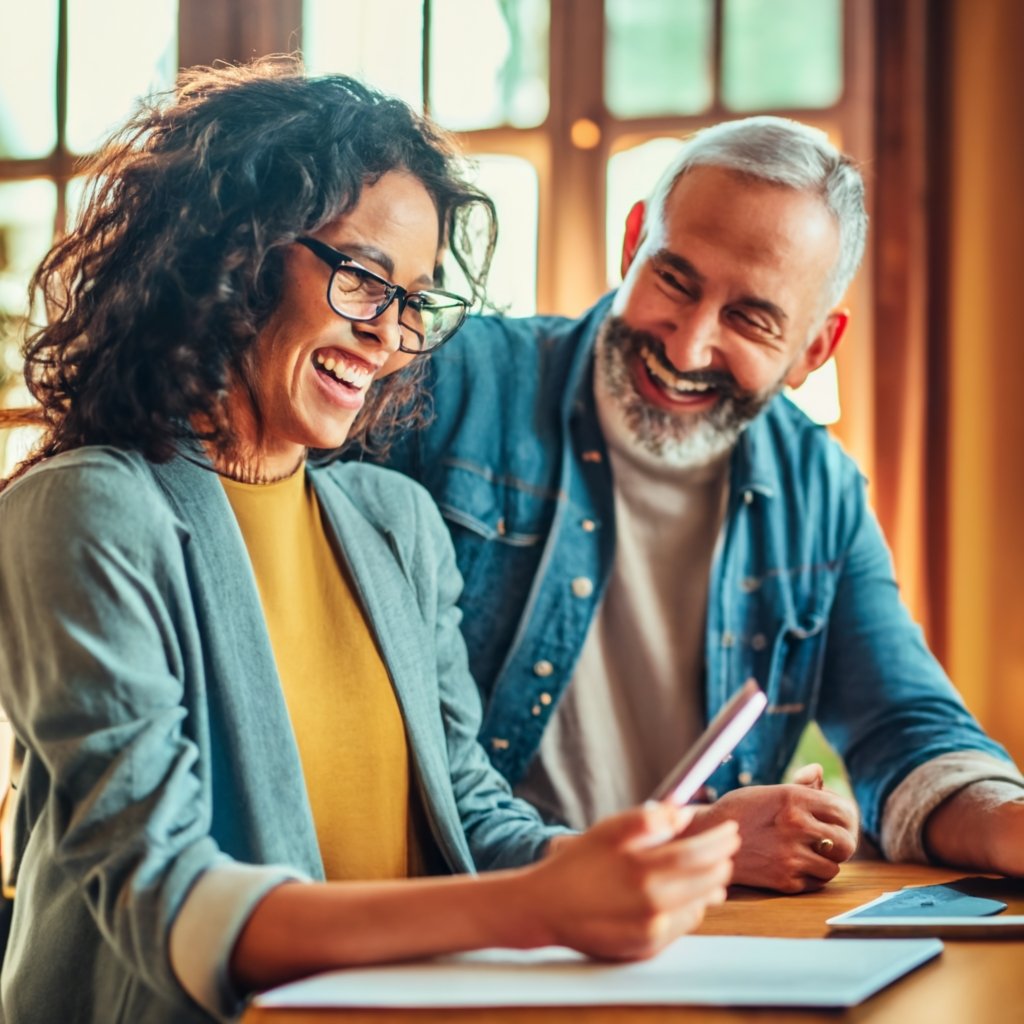 A happy international couple sitting together with the I-129F form, symbolizing the start of their journey towards a shared life in the U.S.