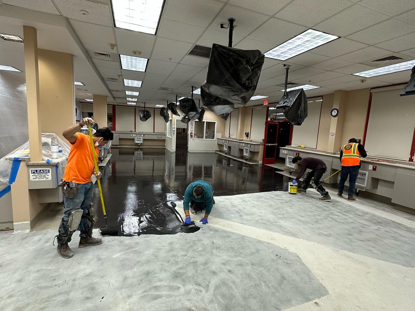 Installer spreading moisture sealer across a freshly ground slab