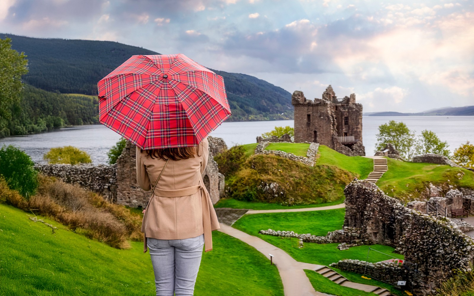 スコットランドの秋、アーカート城を訪れる観光客はスコティッシュ柄の傘を持っています。舞台はネス湖です。