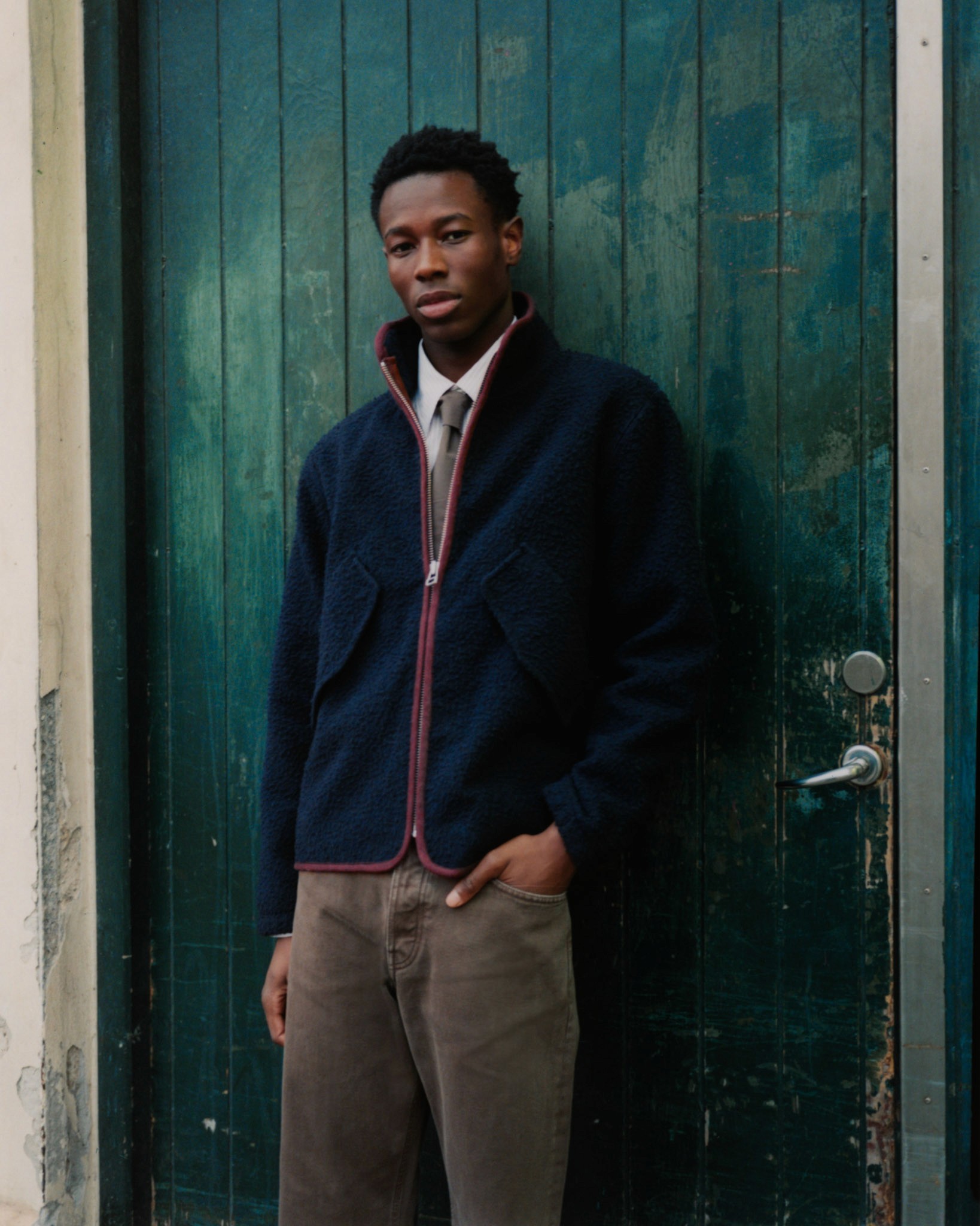 Dans le lookbook de la marque Danoise Another Aspect, le mannequin porte une veste en polaire de laine noire, une cravate et un jean large