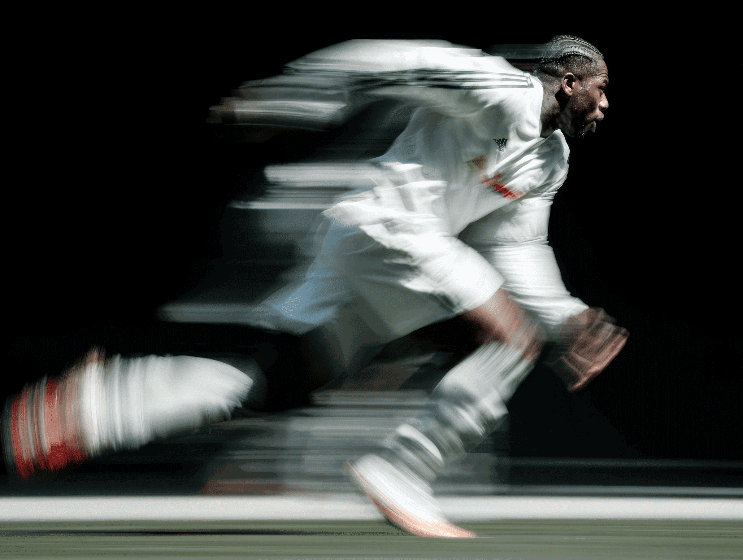 A male athlete in motion blur, sprinting forward in a white suit