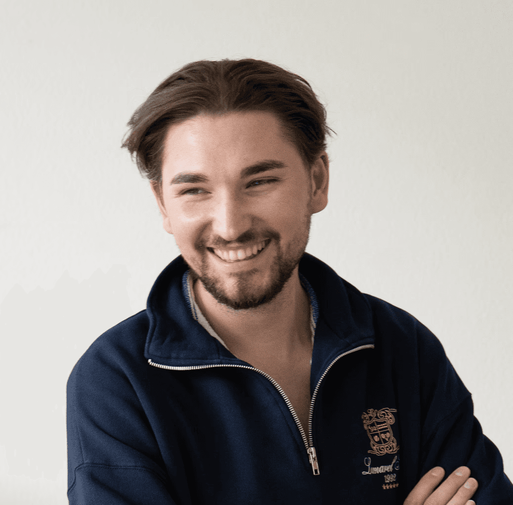 Portrait of a person in a pink sweater against a light background