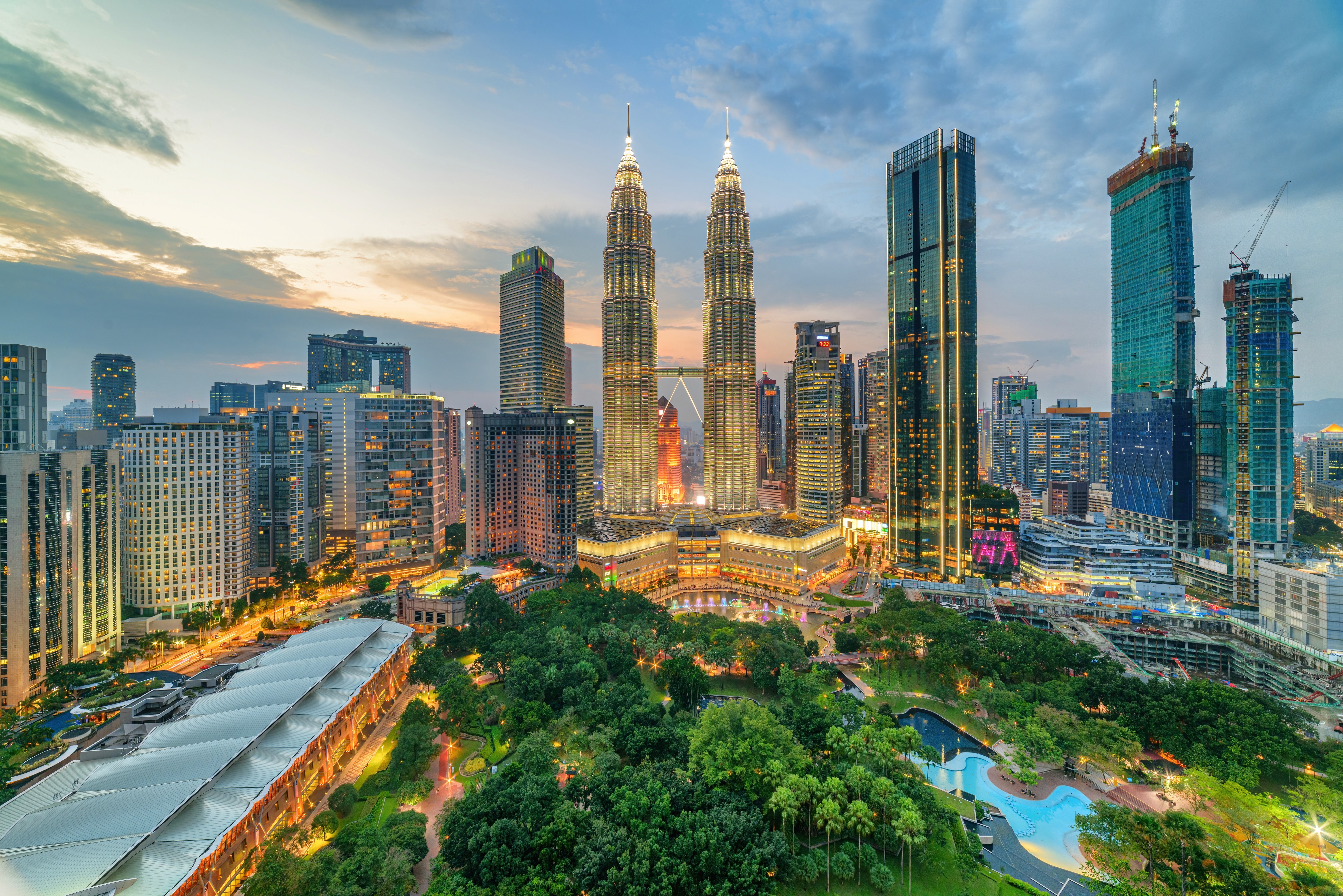 Petronas Towers, Kuala Lumpur skyline with modern skyscrapers and city park.