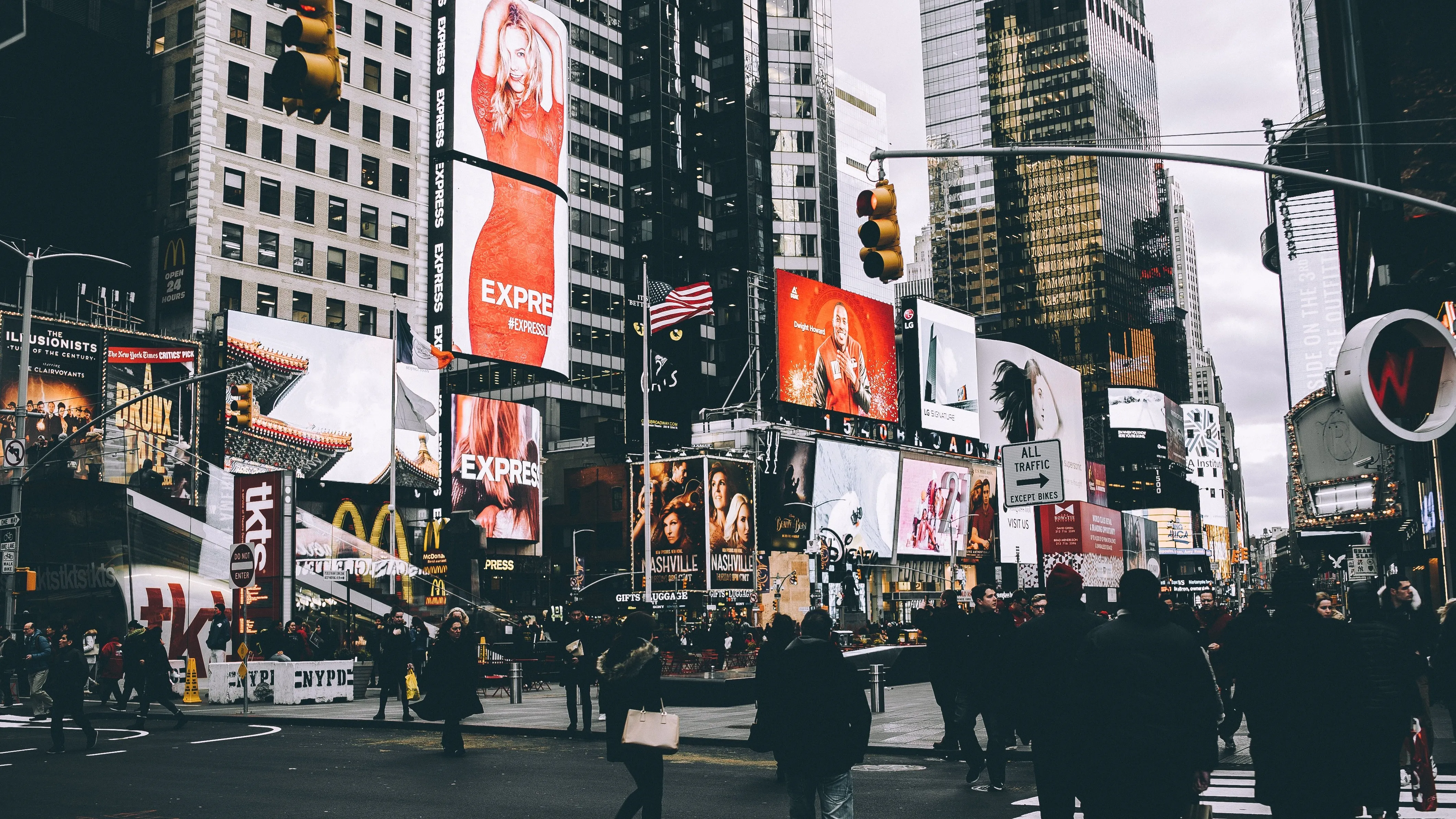 a man walking down a street past a large poster