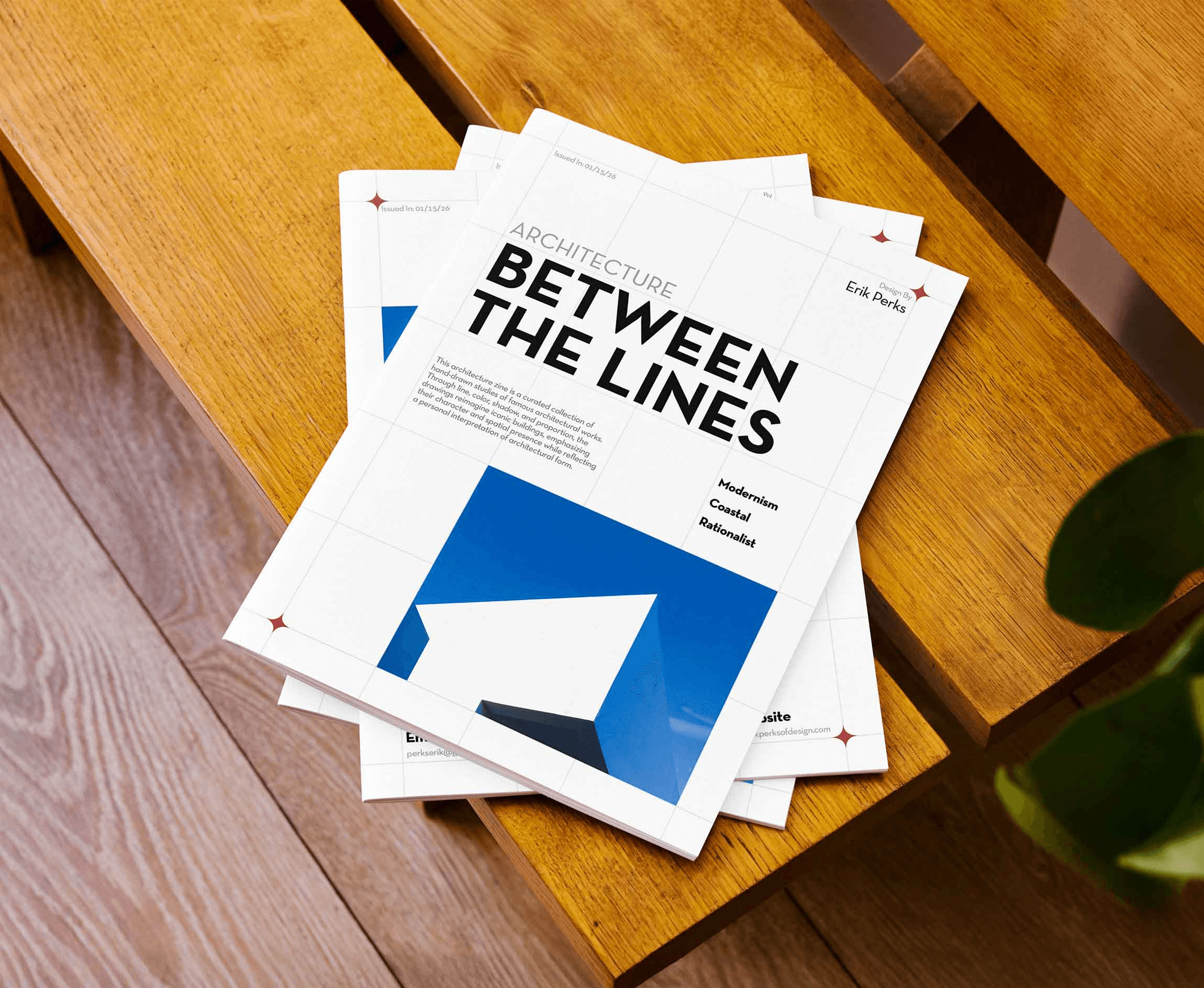 A stack of Between the Lines architecture zine on a wooden bench