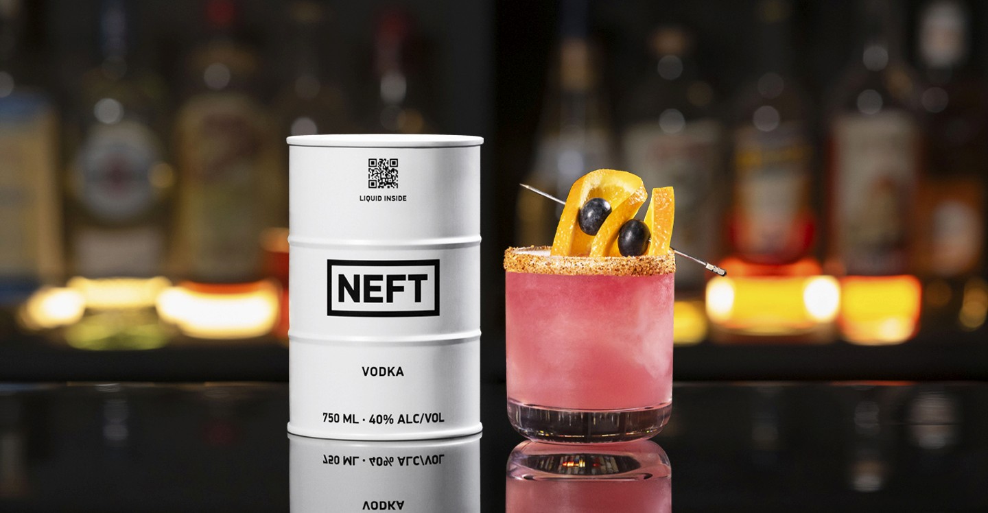 A NEFT Barrel and a glass of Blueberry NEFT-A-Rita  on a bar counter.