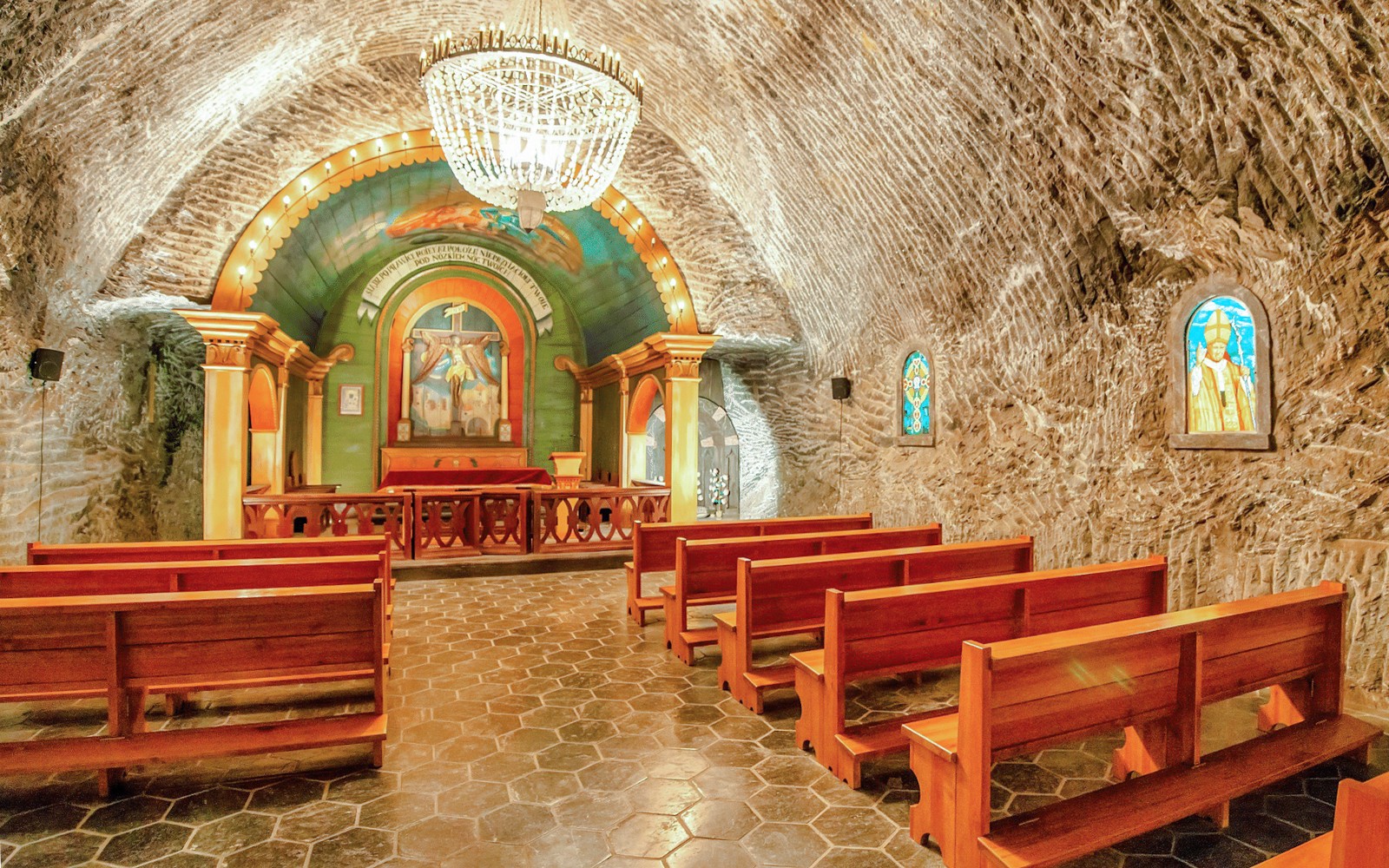 Innrétting kapellu í Wieliczka Salt Mine með viðarbekkjum og skreyttum altari.