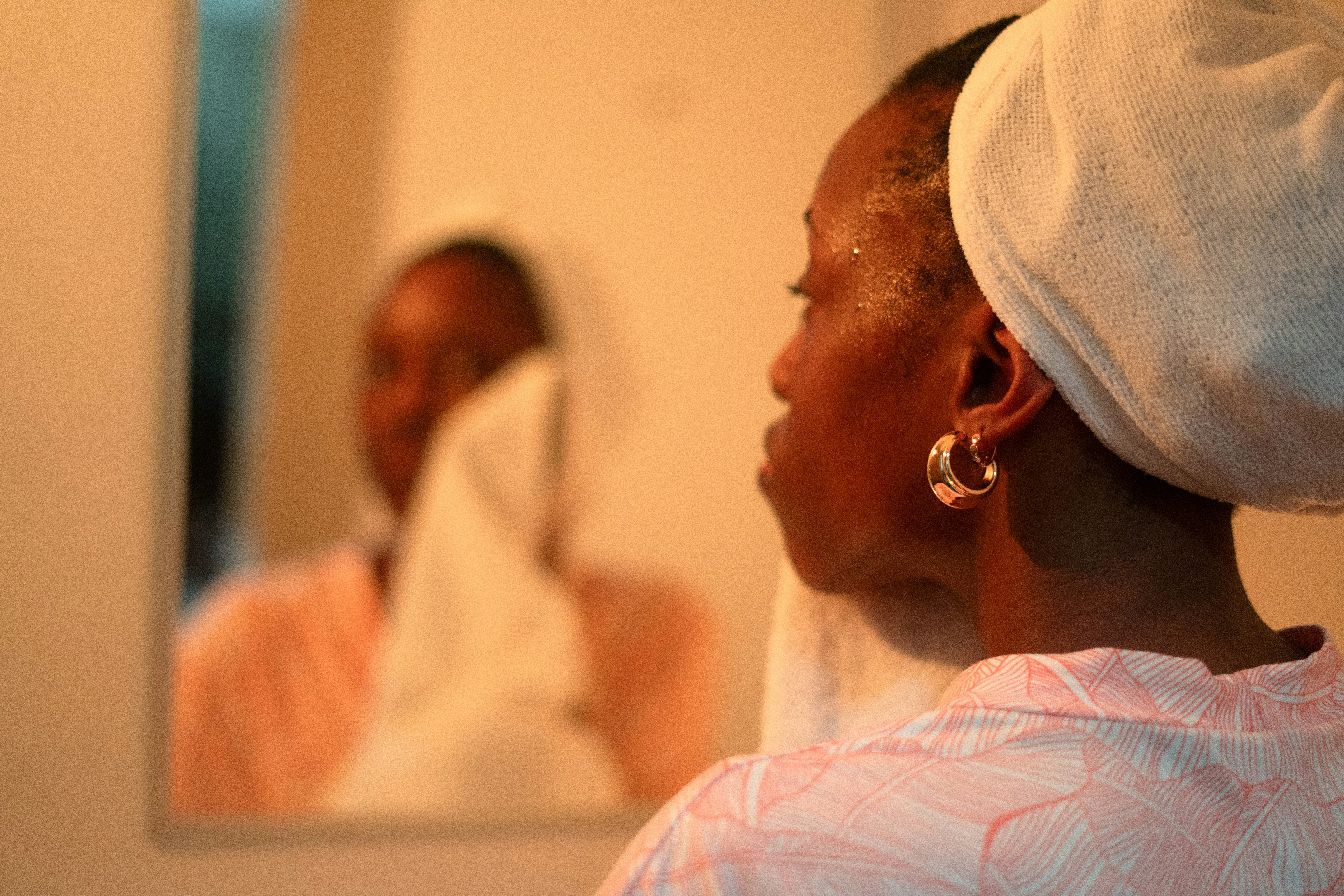 Woman looking in mirror with skin concerns