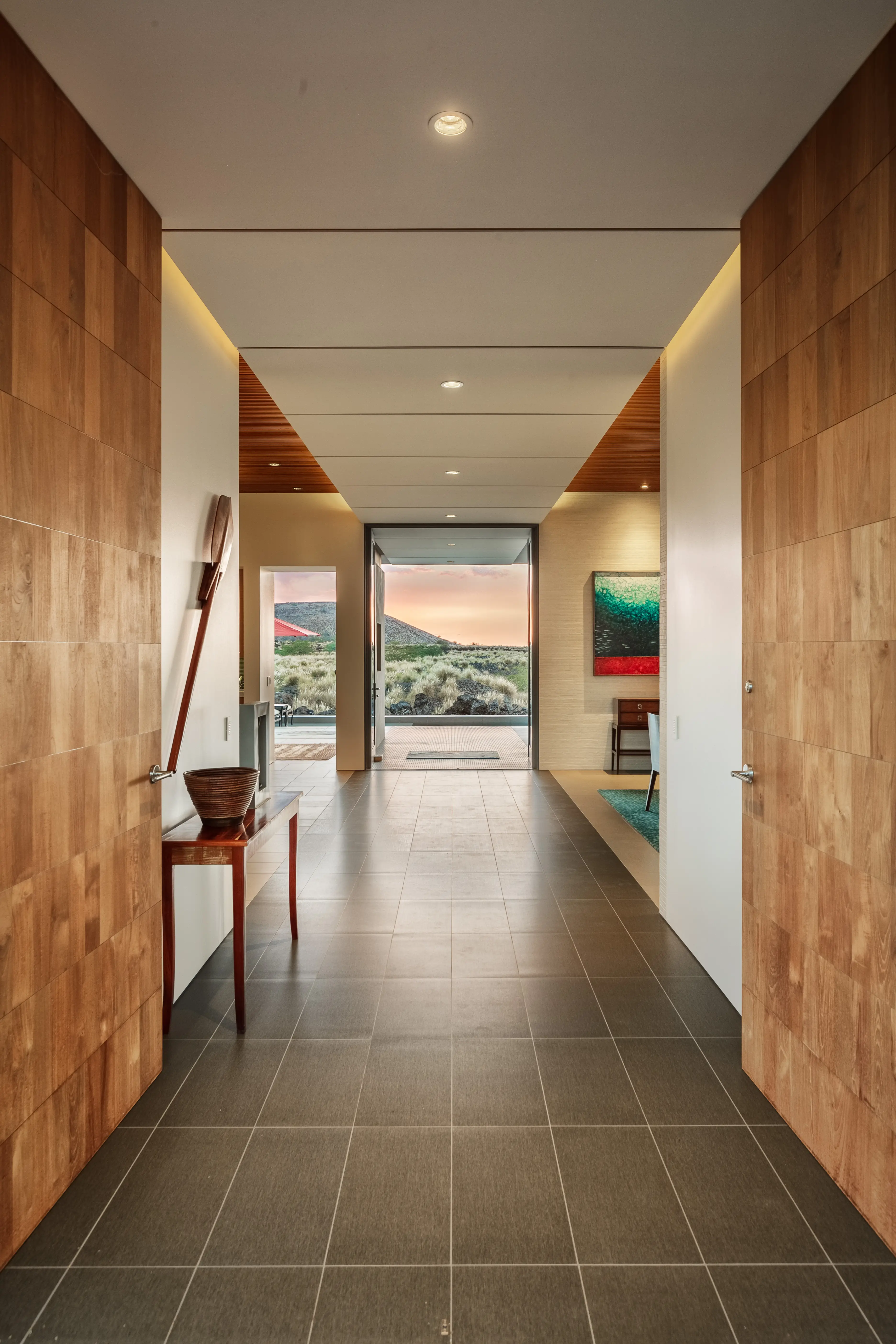 Timber-lined entry hall framing a sunset view, Kūkiʻo