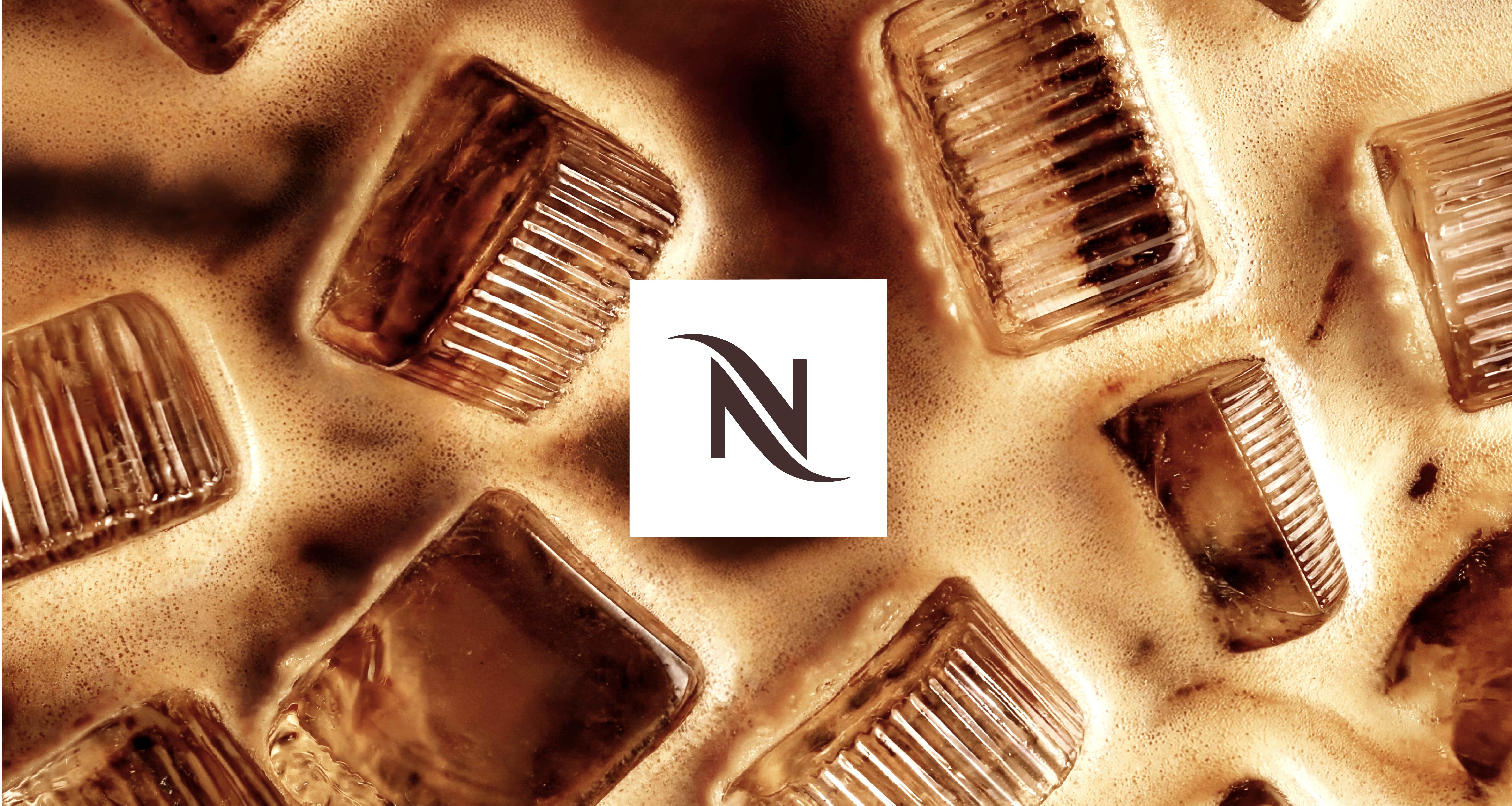 Nespresso monogram set on top of an indulgent image of ice cubes in coffee