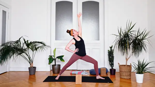 Pregnant woman in a strong standing warrior yoga pose – prenatal yoga class to build confidence and inner strength through solar plexus activation