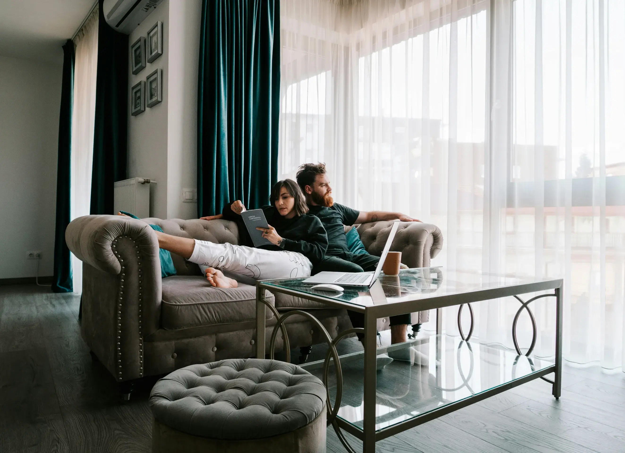 couple sitting on sofa near window