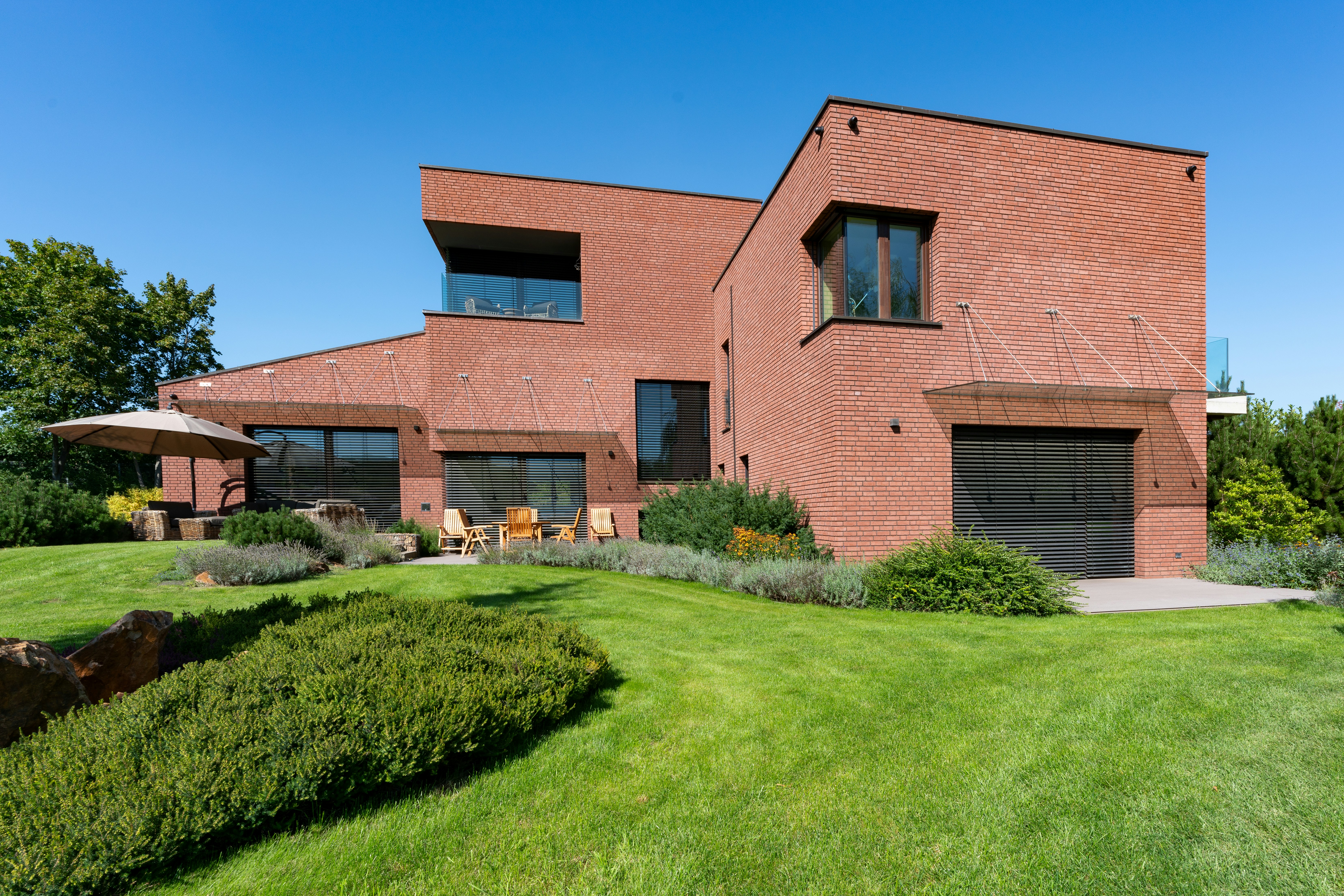 a large brick house with a green lawn in front of it