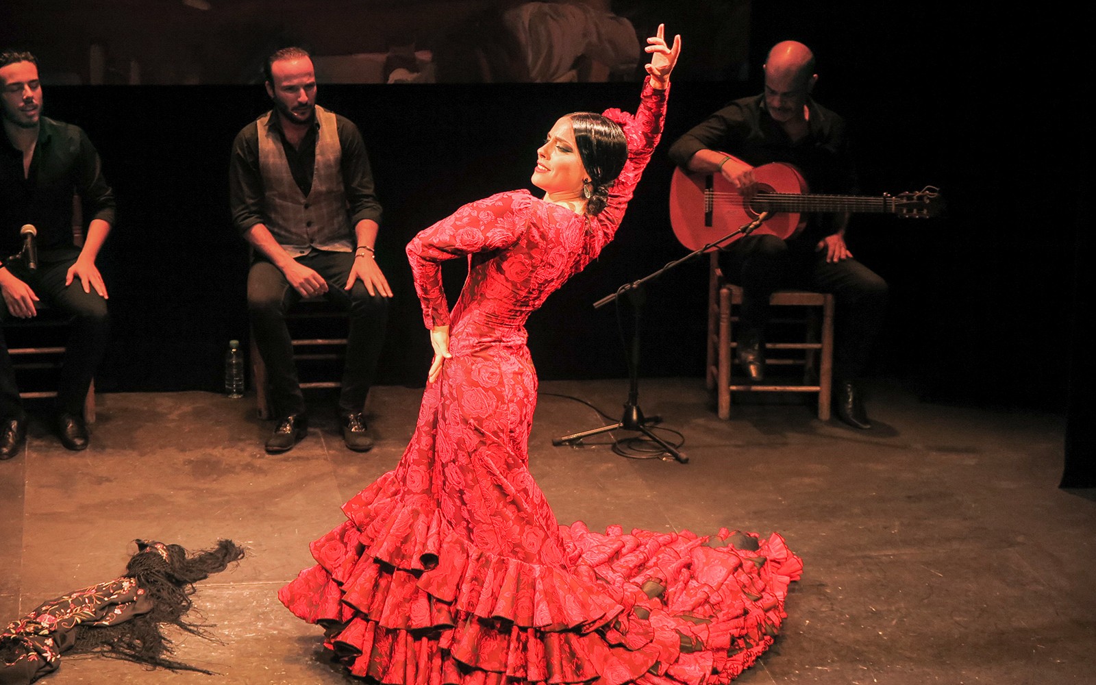 Flamenco dancer performing at Teatro Flamenco Triana with musicians.