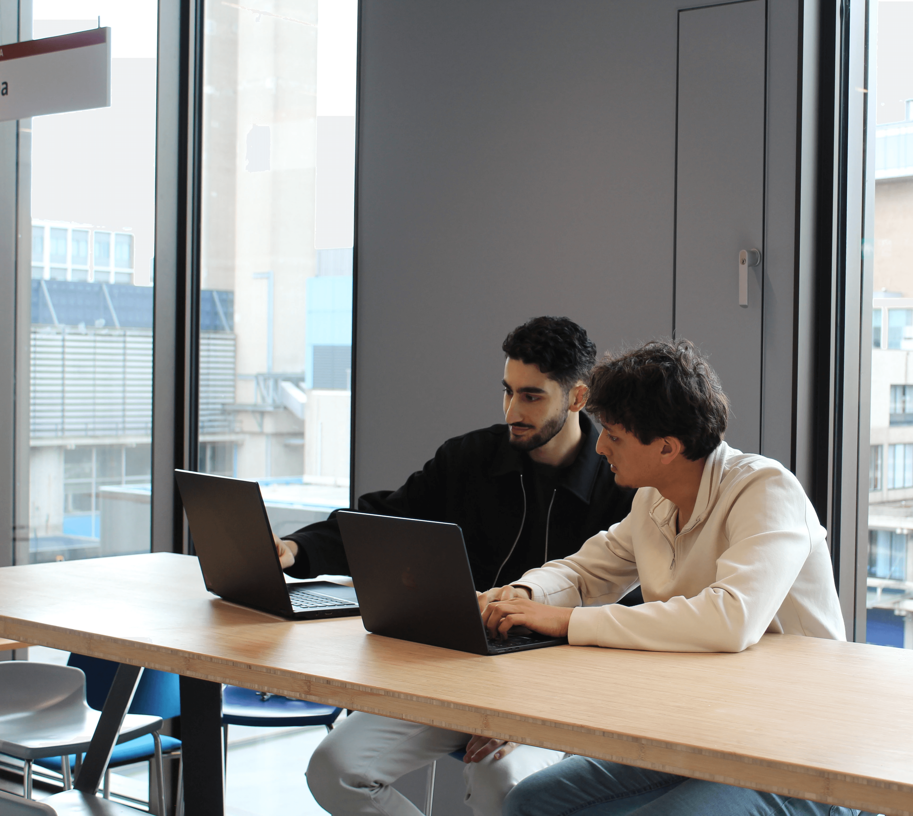 3 mensen aan een tafel achter hun laptop