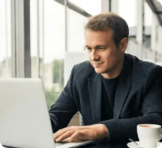 Business professional working on a laptop while reviewing customer payments and invoices.