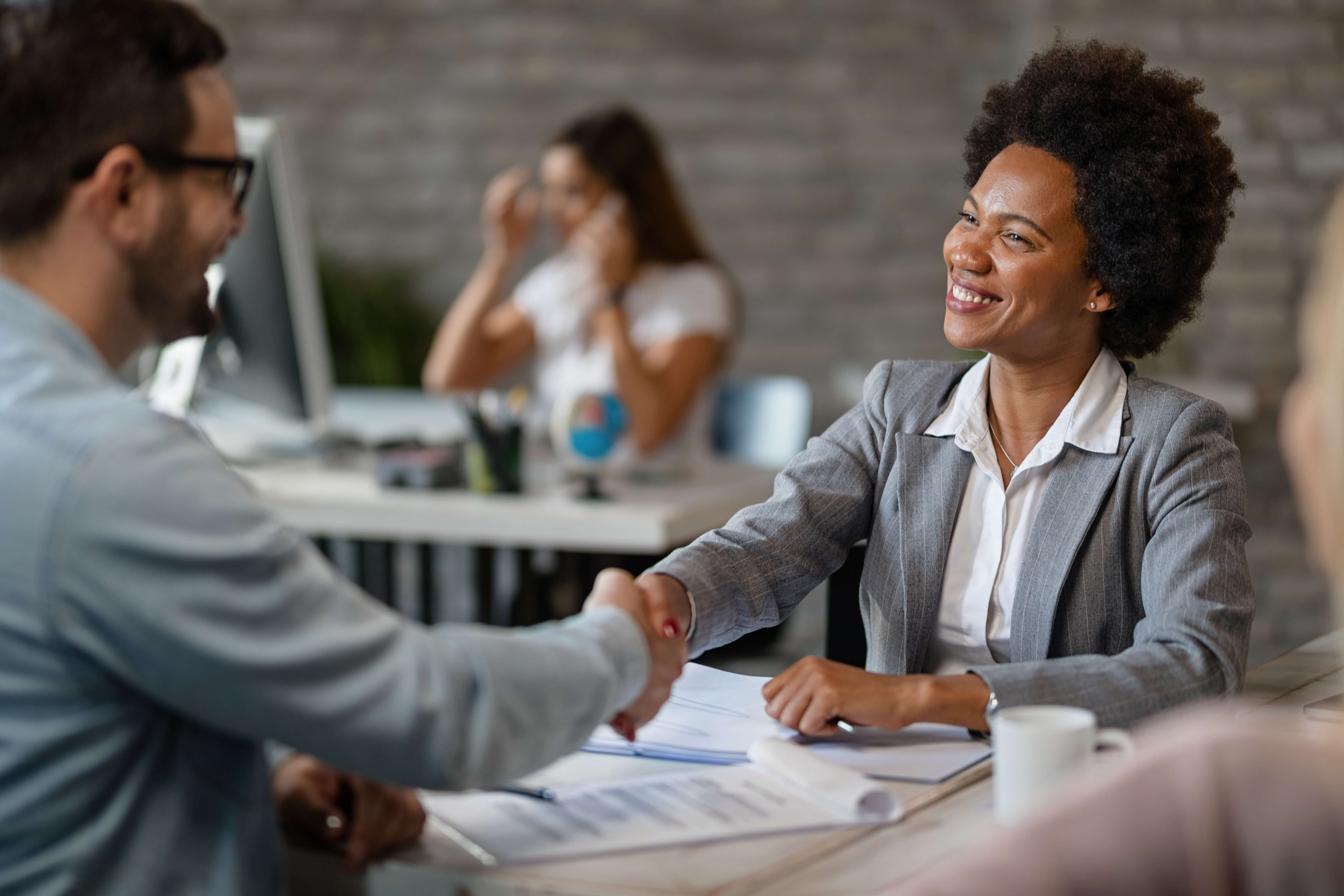 Happy African client shaking hands